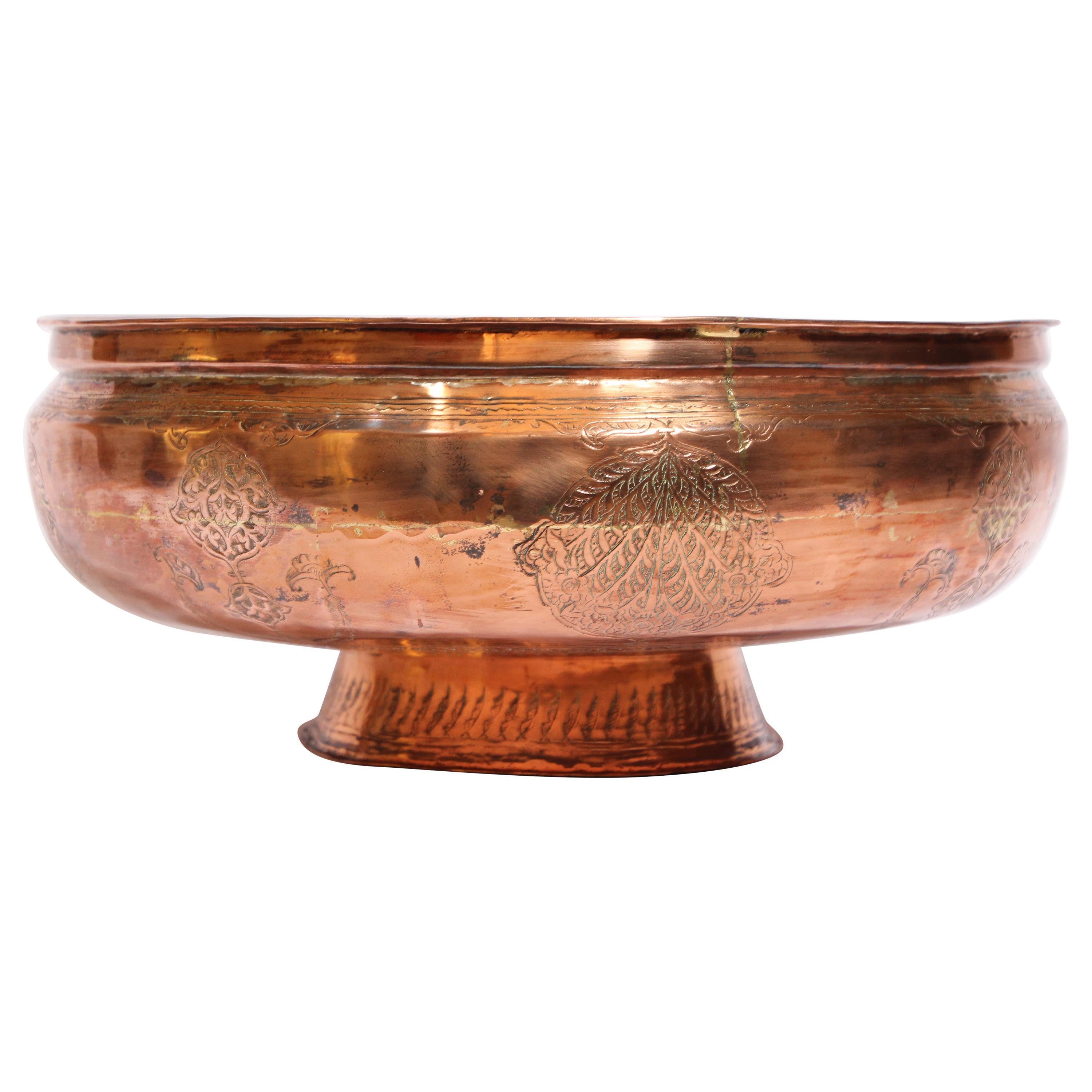 Mughal Islamic Indo Persian red copper footed bowl, of compressed hemispherical shape, resting on a splayed conical foot, with slightly everted rim, finely hand-etched, hammered and chased with elaborate Moorish designs decorated with medallions of