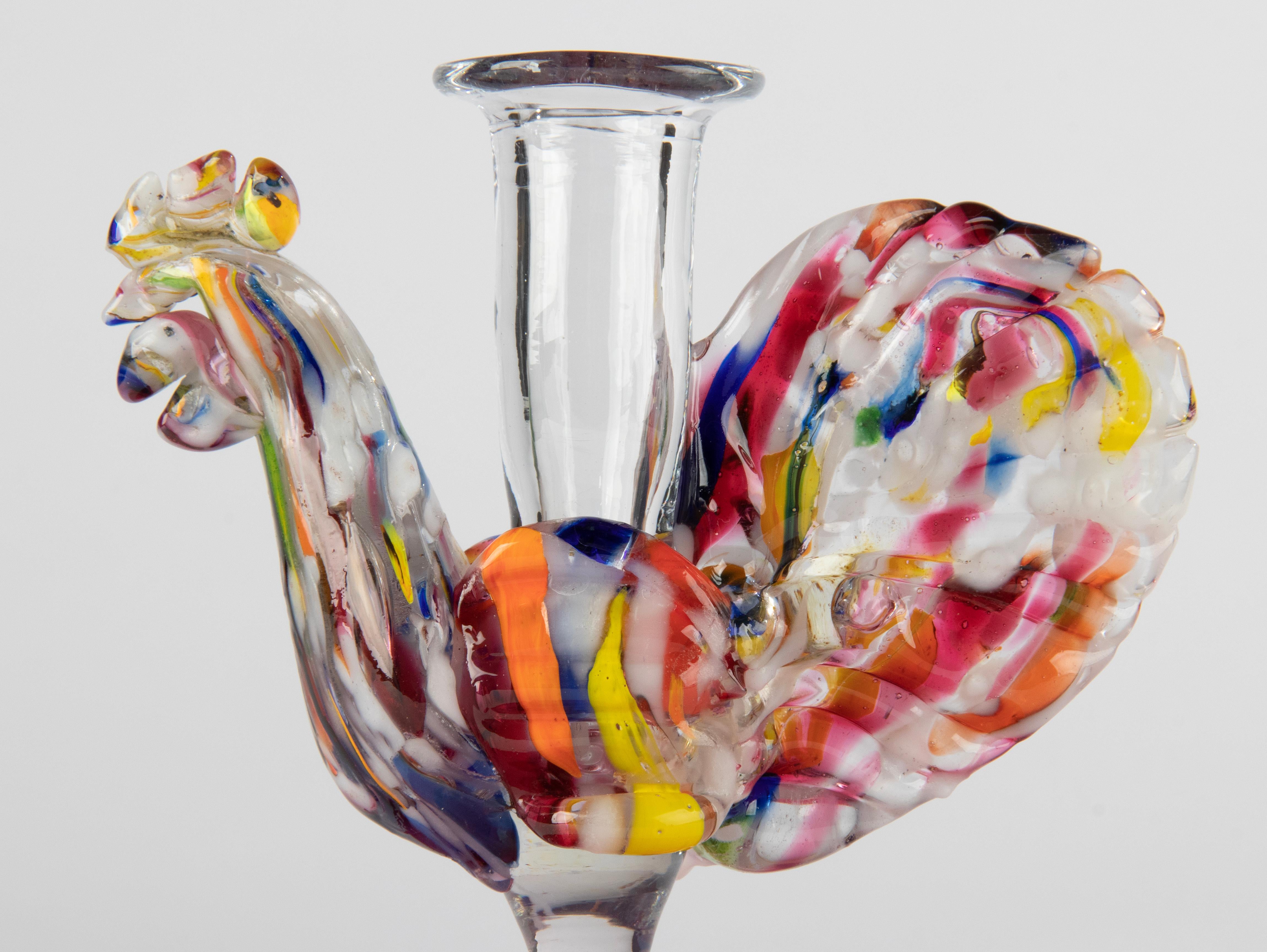 Beautiful antique paperweight, handmade from multi colored glass, in the shape of a rooster. On top a small vase, probably intended to hold a pen. This object is in good condition.