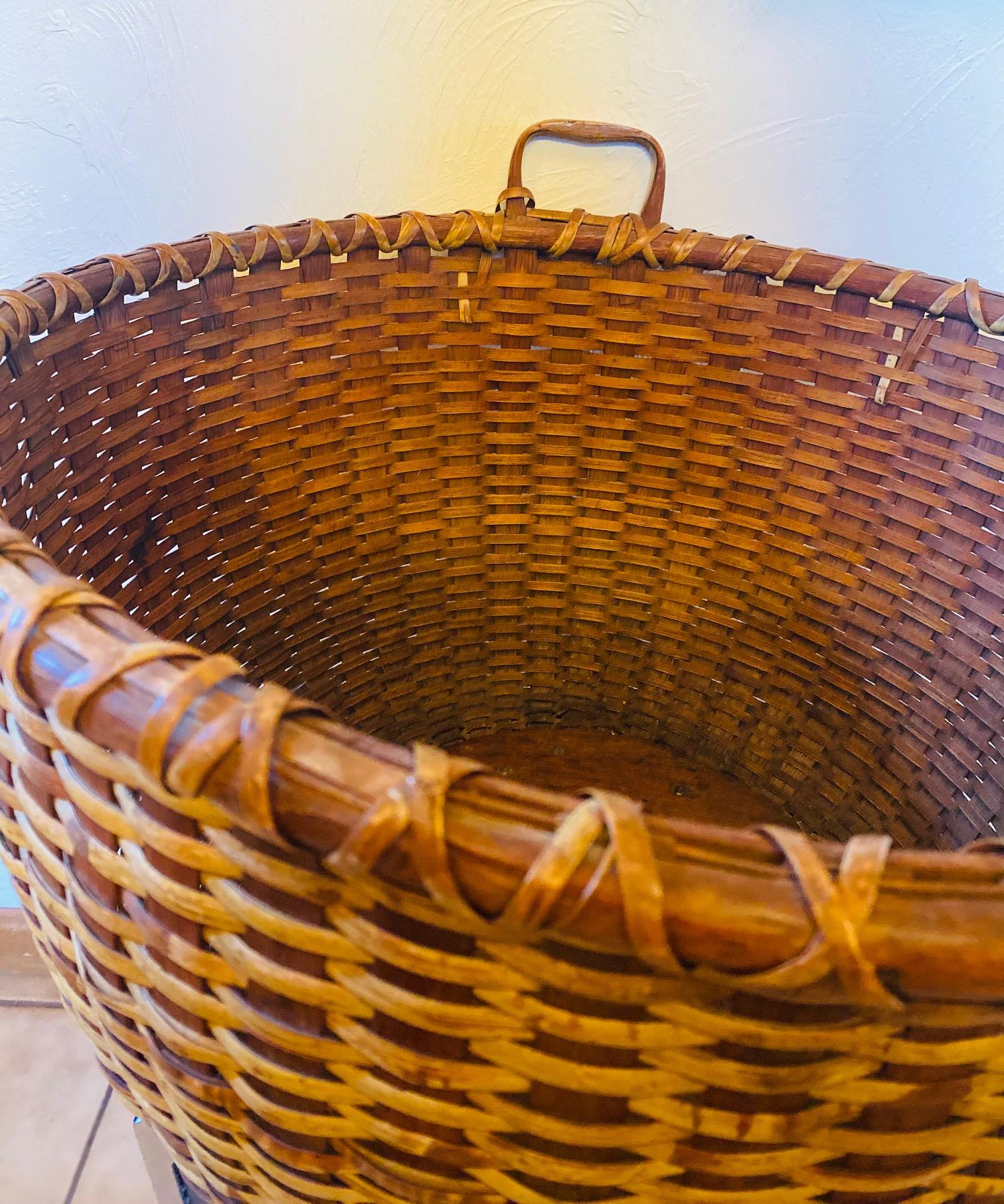 Very rare 19th century Nantucket Lightship Bushel Basket by George C. Gardner of Nantucket Island (1809 - 1889), an oversized round open basket handcrafted with a fat rattan weave on wide wooden splint staves, a carved wooden heart-shaped handle