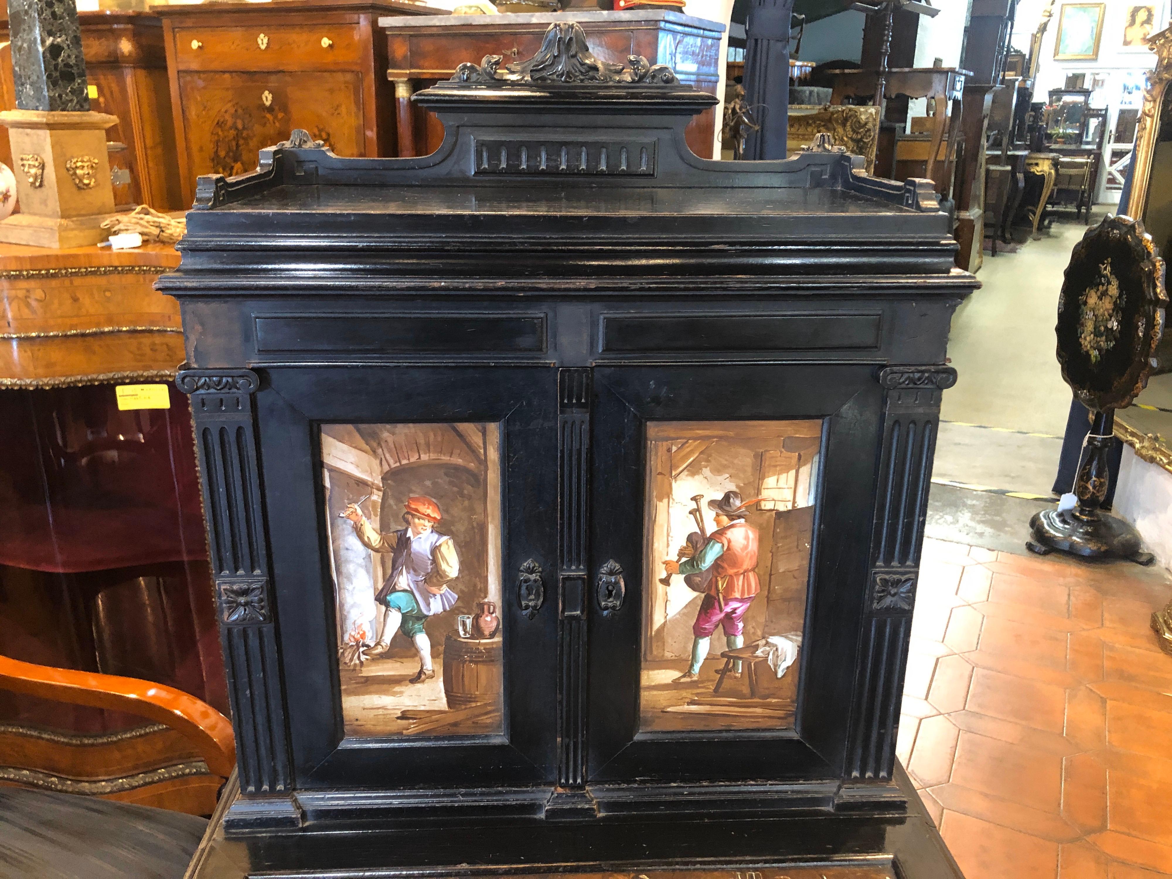 Ebonized furniture of Belgian origin, ceramic applications painted with scenes of everyday life in a Inn, Napoleon III era, circa 1850.
Finely ornamented with floral motifs, tip-up top where the leather or cloth can be put back, a drawer and two