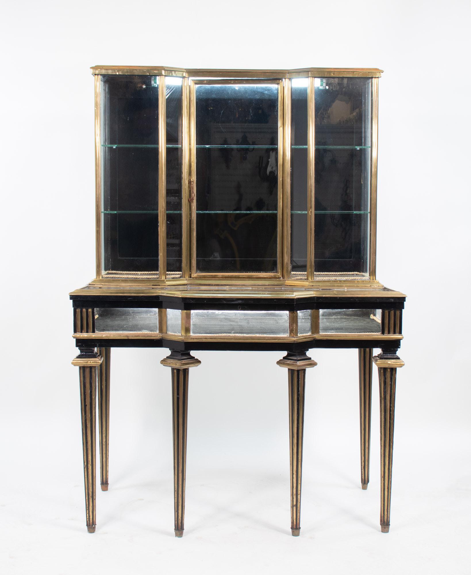 Esempio di artigianato francese dell'epoca di Napoleone III, questa vetrina in lacca nera e ottone, risalente al 1870 circa, emana eleganza e raffinatezza. Il mobile superiore è dotato di due ripiani interni in vetro regolabili e la vetrina si apre