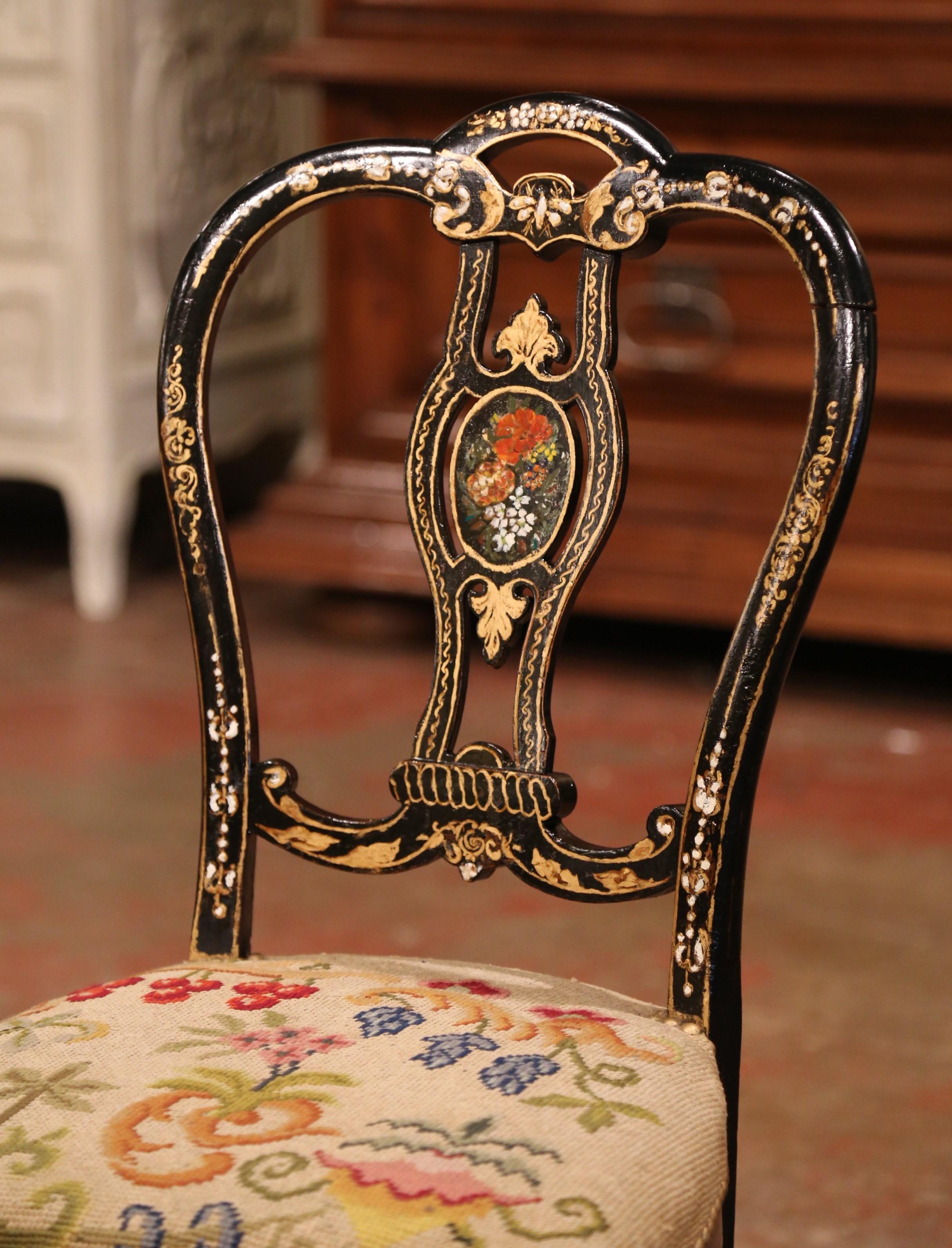 This elegant and colorful antique chair was crafted in France, circa 1870. The petite chair frame stands on four curved legs with carved stretcher over a bombe scalloped apron, and features a ladder back with central spindle. The chair is decorated