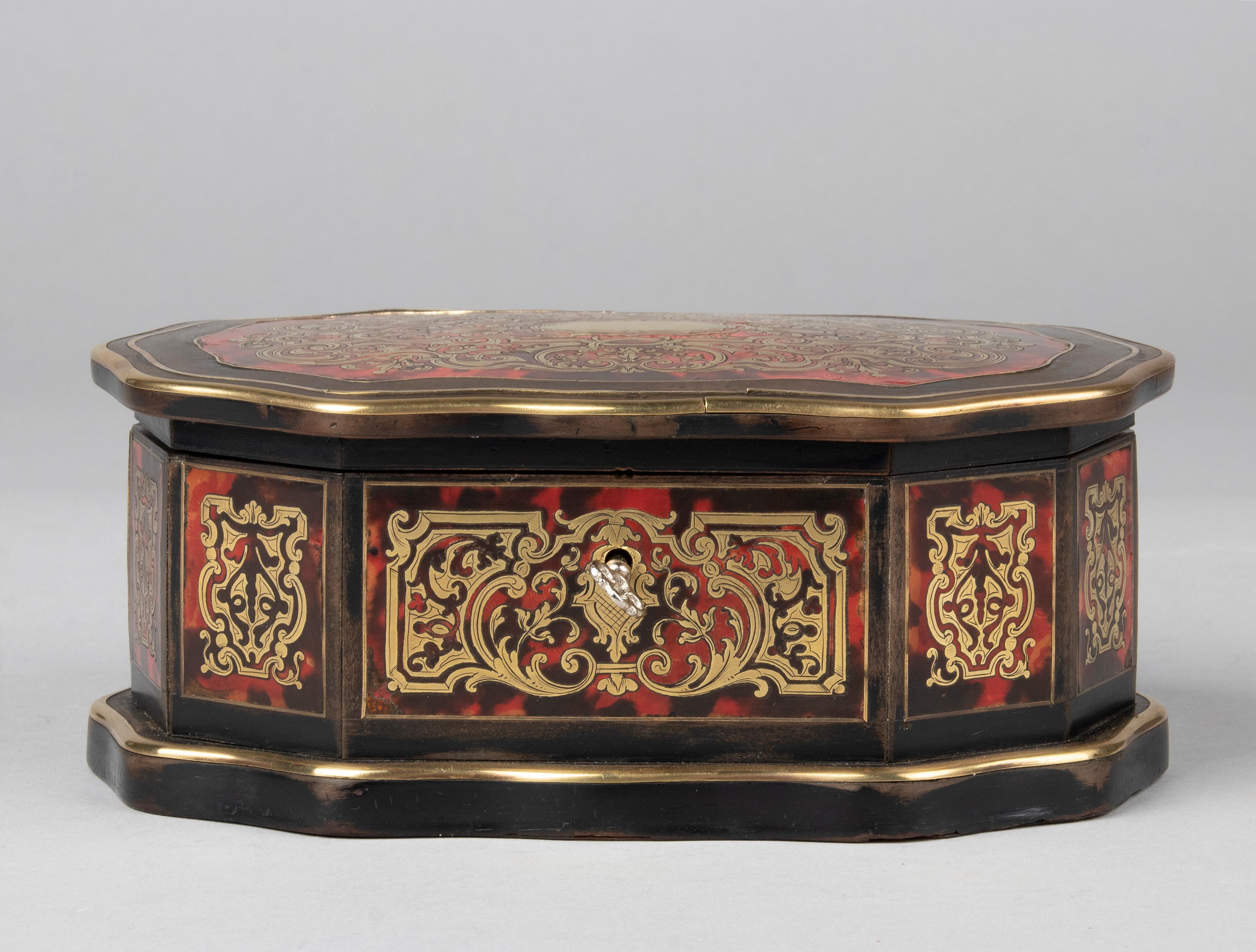 Beautiful and elegant antique French box from the Napoleon III style period.
The box is made of blackened wood, inlaid with boulle and copper marquetry. The box has a working lock with key. The box is in good condition. The interior is lined with