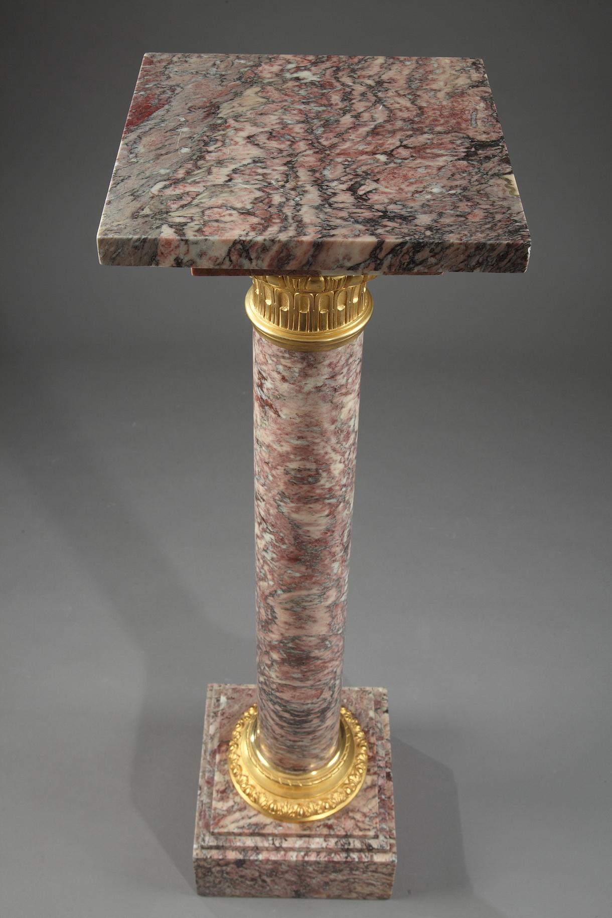 Brocatelle marble display column with sculpted and gilt bronze cap and base. The capital is embellished with ovals and fluting, and the base is decorated with alternating ovals and palmettes. The ensemble is set on a square, terraced base. Napoleon