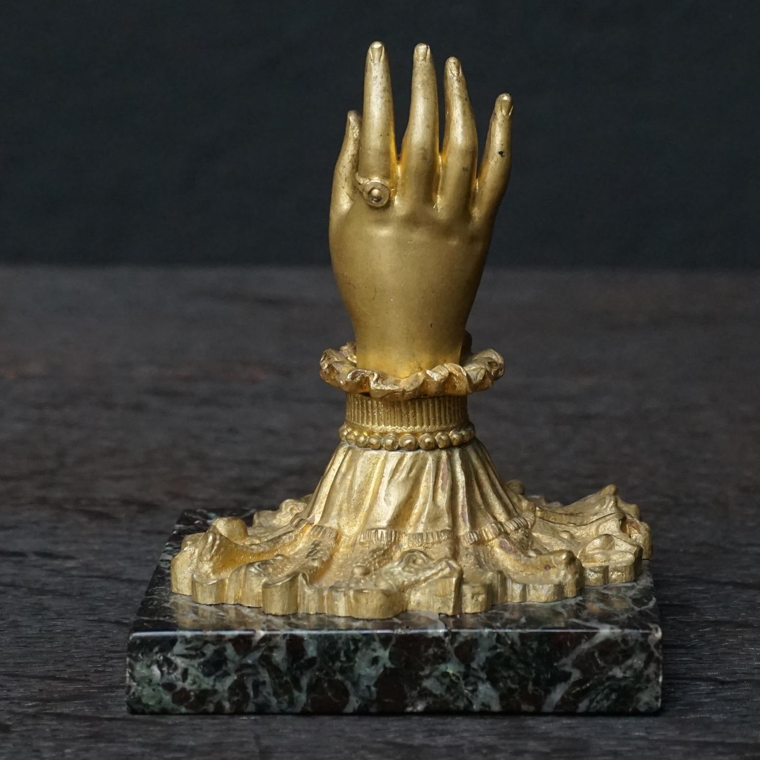 Very nice little Napoleon III paperweight or presse papier.
Bronze gilt elegant ruffled shirt cuffed and ringed ladies hand on a black marble.
Could also be used as ring holder or to present a little stack of business card in. 

Nice grounding