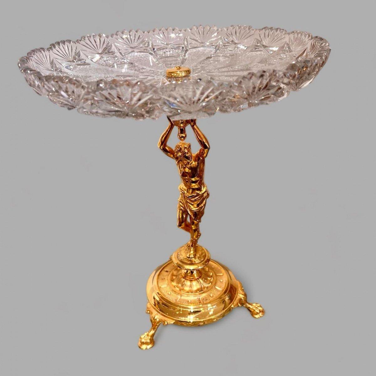 Nous vous présentons cette exquise coupe décorative en cristal taillé avec une base en bronze doré de la période Napoléon III au 19ème siècle. La base représente un homme en tenue classique de l'Antiquité grecque tenant à bout de bras la coupe de
