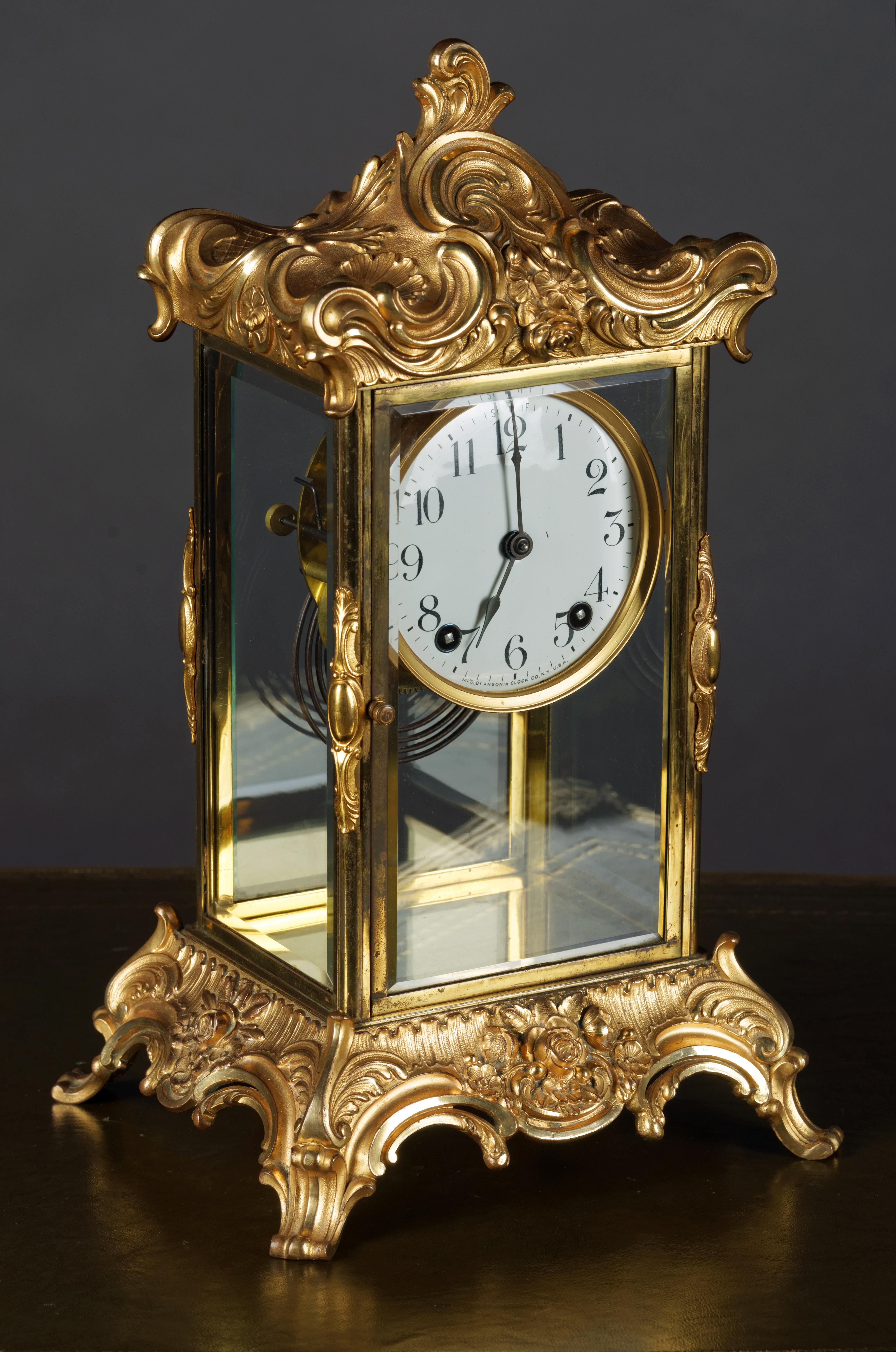 Fire-gilt fireplace clock, Rokokodekor sign. Ansonia New York, 19th century.
Bronze-gilt. Four-sided glazed housing on base with reliefed seed beads, leaves and flowers.
Approved roof trim. Digits sheet email with Arabic numerals. Brocothemia. Steel