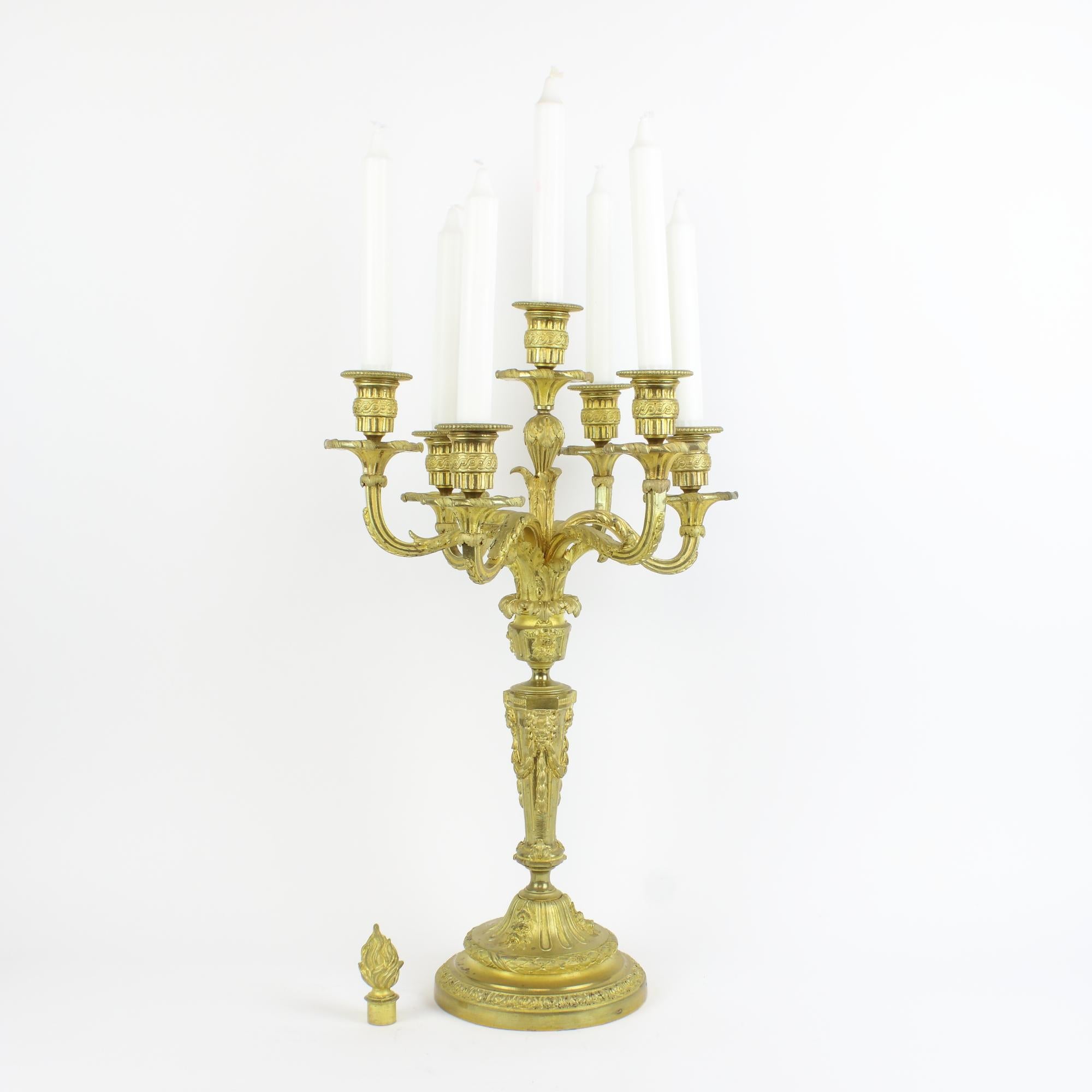19th century French gilt bronze 7-Light Louis XVI candelabra in the manner of Jean-Charles Delafosse (1734-1789)

The tapering stem standing on a circular base cast with foliage and decorated with lion heads holding festoons with their teeth. The