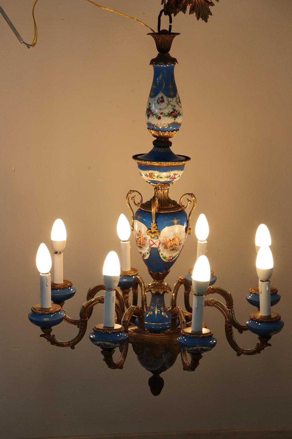 Splendid Napoleon III chandelier in gilded bronze and fine sevres porcelain with 8 lights, 1880s. The bronze is finely chiseled. The porcelain in the colors of blue is hand painted with a refined floral decoration. Some scenes with delicate little