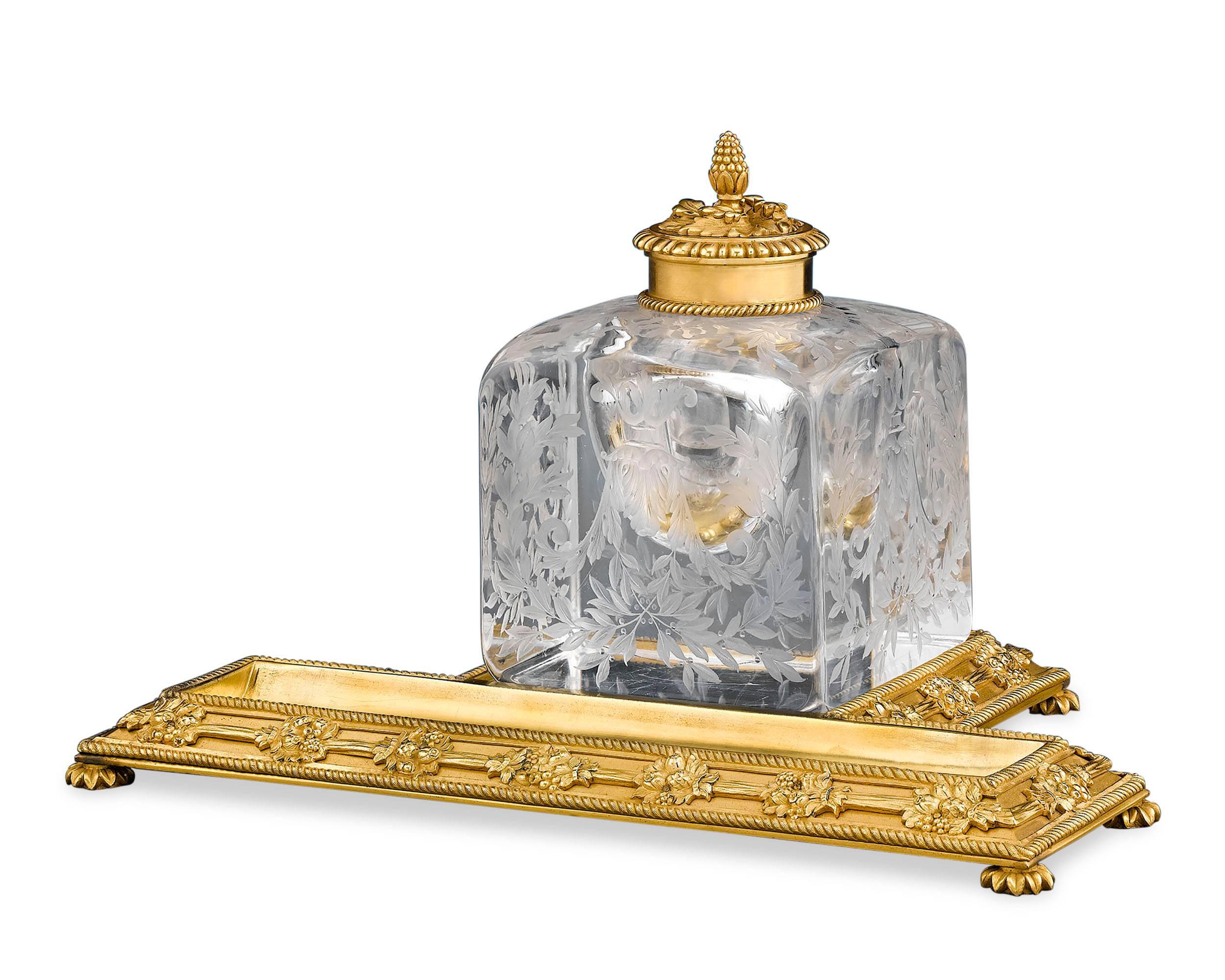 A work of impeccable beauty, this gilt bronze and glass inkwell Standish embodies the best of the Napoleon III style. Comprised of a beautifully etched, solid glass inkwell set upon an ormolu stand decorated with foliage and gadrooned feet, this