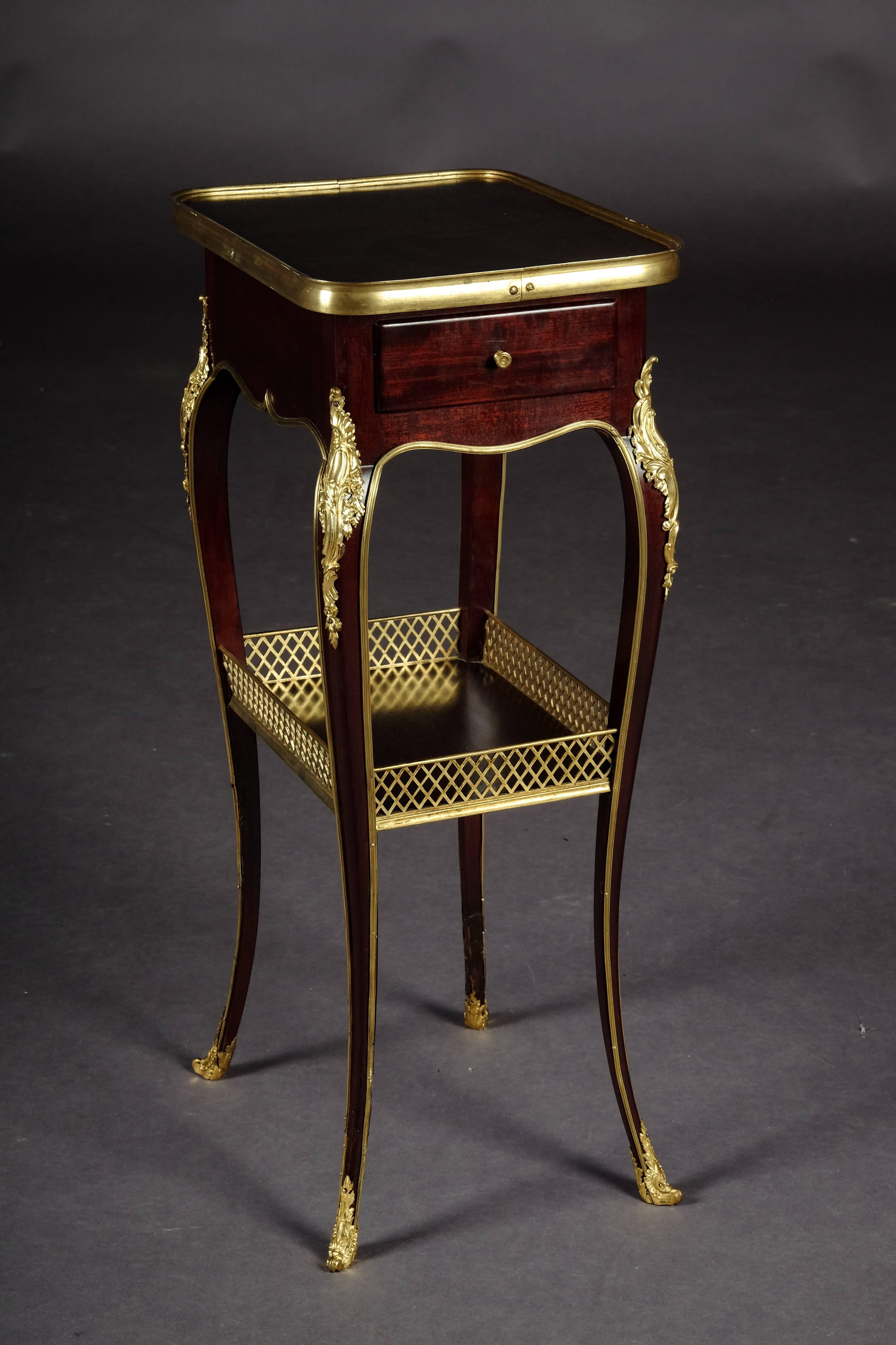 Solid mahogany and polished oak. Embracing frame box on high slightly curved legs with intermediate tray connected in sabots. Slightly protruding top plate in brass frame.

(G-69).