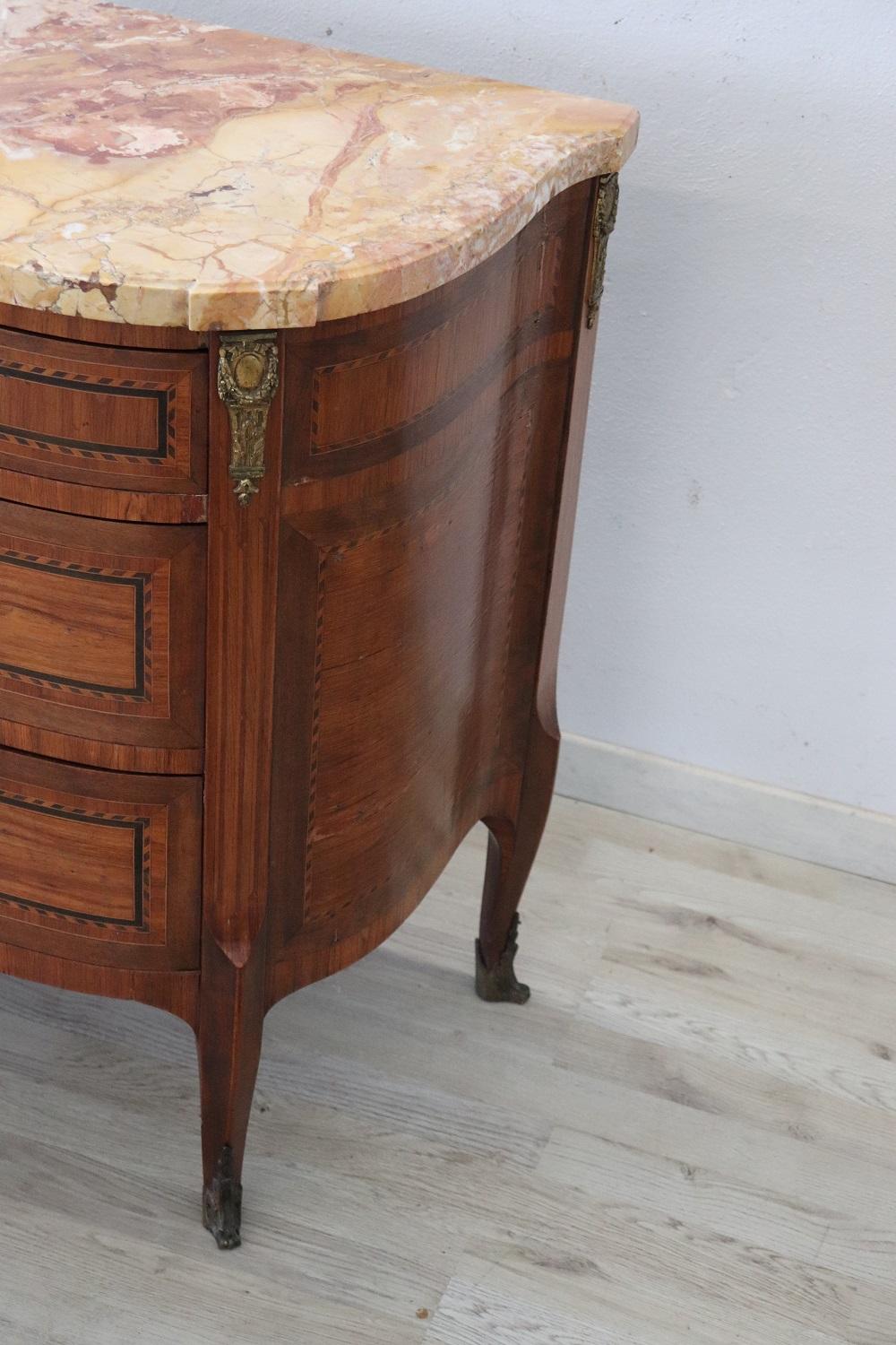 Spectacular 1880s French antique commode in precious inlaid walnut marquetry. The line is typical of the Napoleon III with elegant wavy legs. Rich decoration in finely chiseled bronze makes. The front with three comfortable drawers. The top in fine