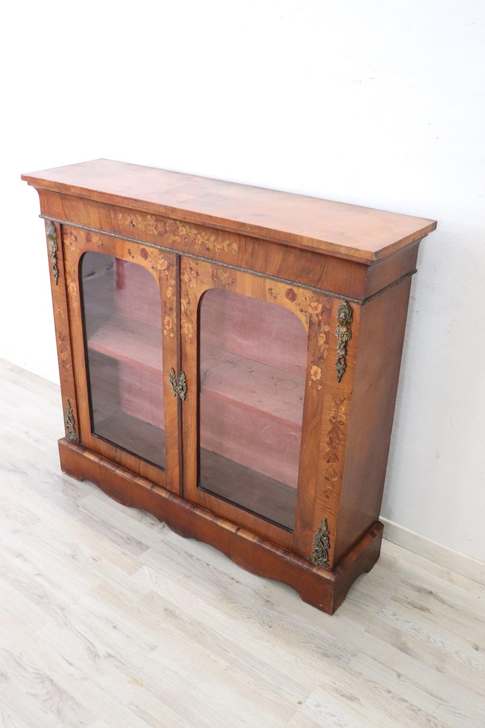 Elegant antique Napoleon III vitrine characterized by finely inlaid walnut. Enriched with precious finely chiseled golden bronzes that cover the vitrine in different parts. Internally lined with precious velvet that shows some signs of wear. Perfect
