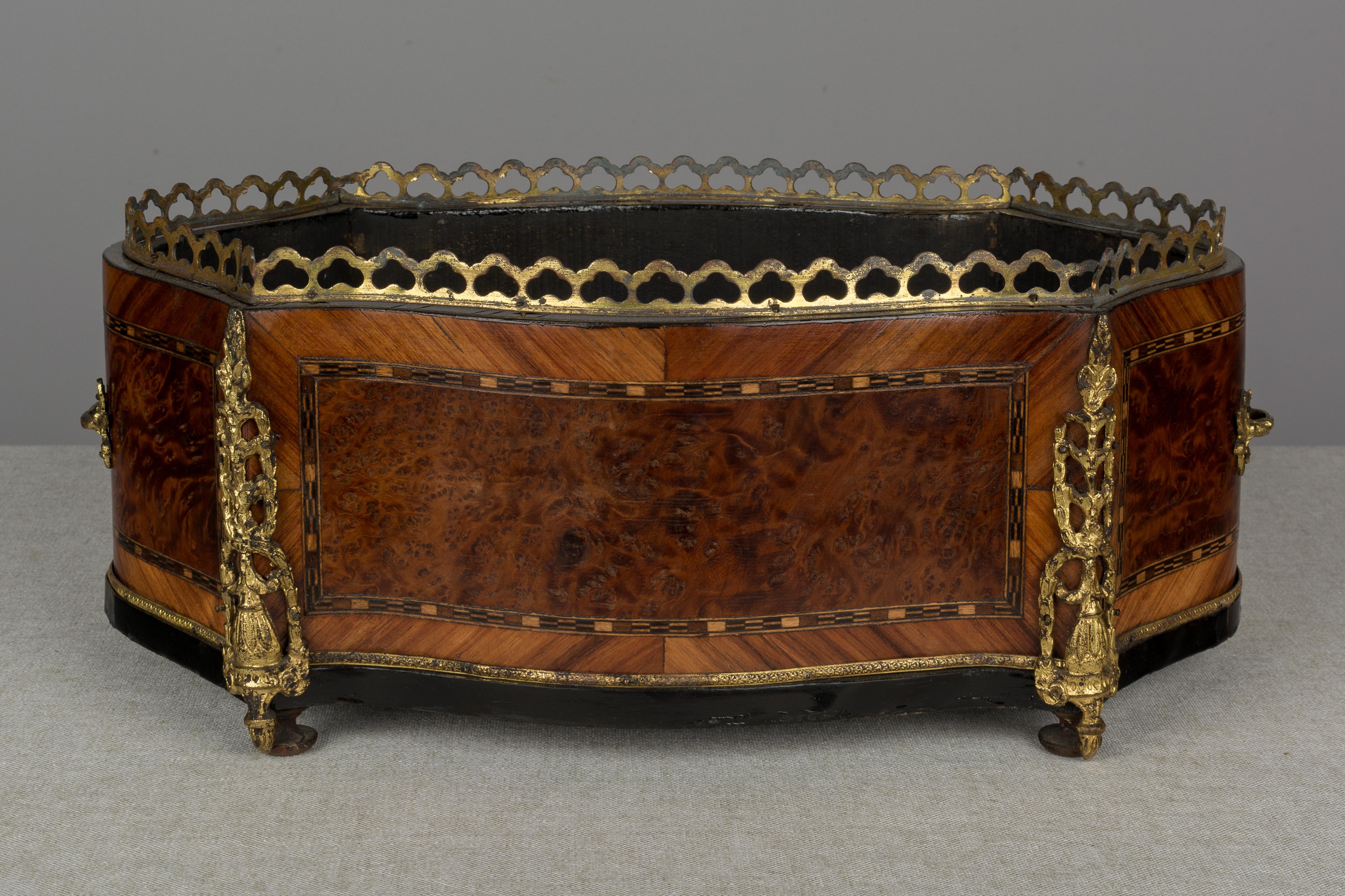 A 19th century Napoleon III marquetry jardinière made of mahogany with burl of walnut veneer and various inlay. Bronze-mounted with two handles, gallery and corner ornaments. Note: there is no zinc liner. A beautiful planter for the display of