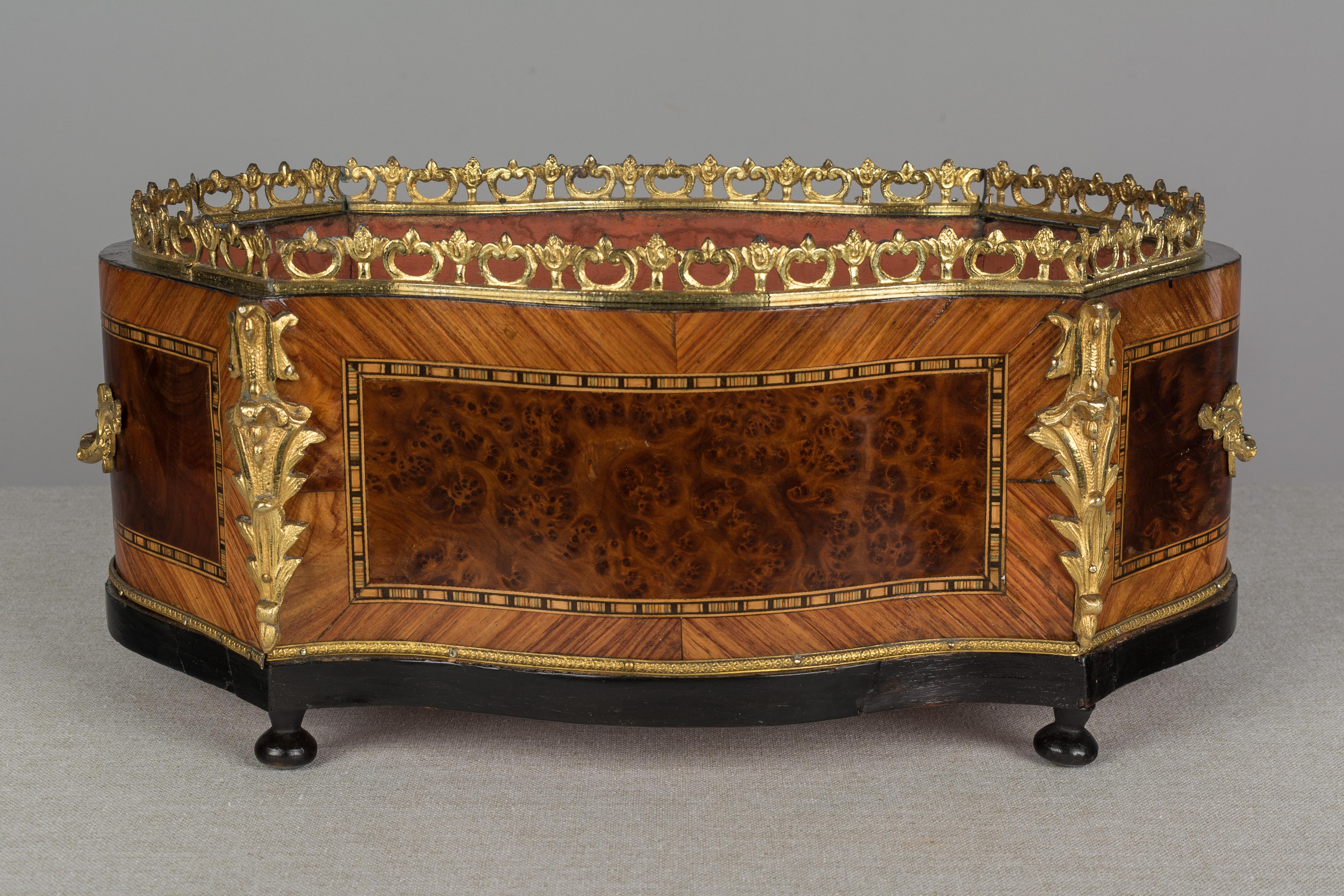 A 19th century French Napoleon III marquetry jardinière made of mahogany with burl of walnut veneer and various wood inlay. Bronze-mounted with two handles, gallery and corner ornaments. Original foil label to underside: P. Sormani. Paul Sormani