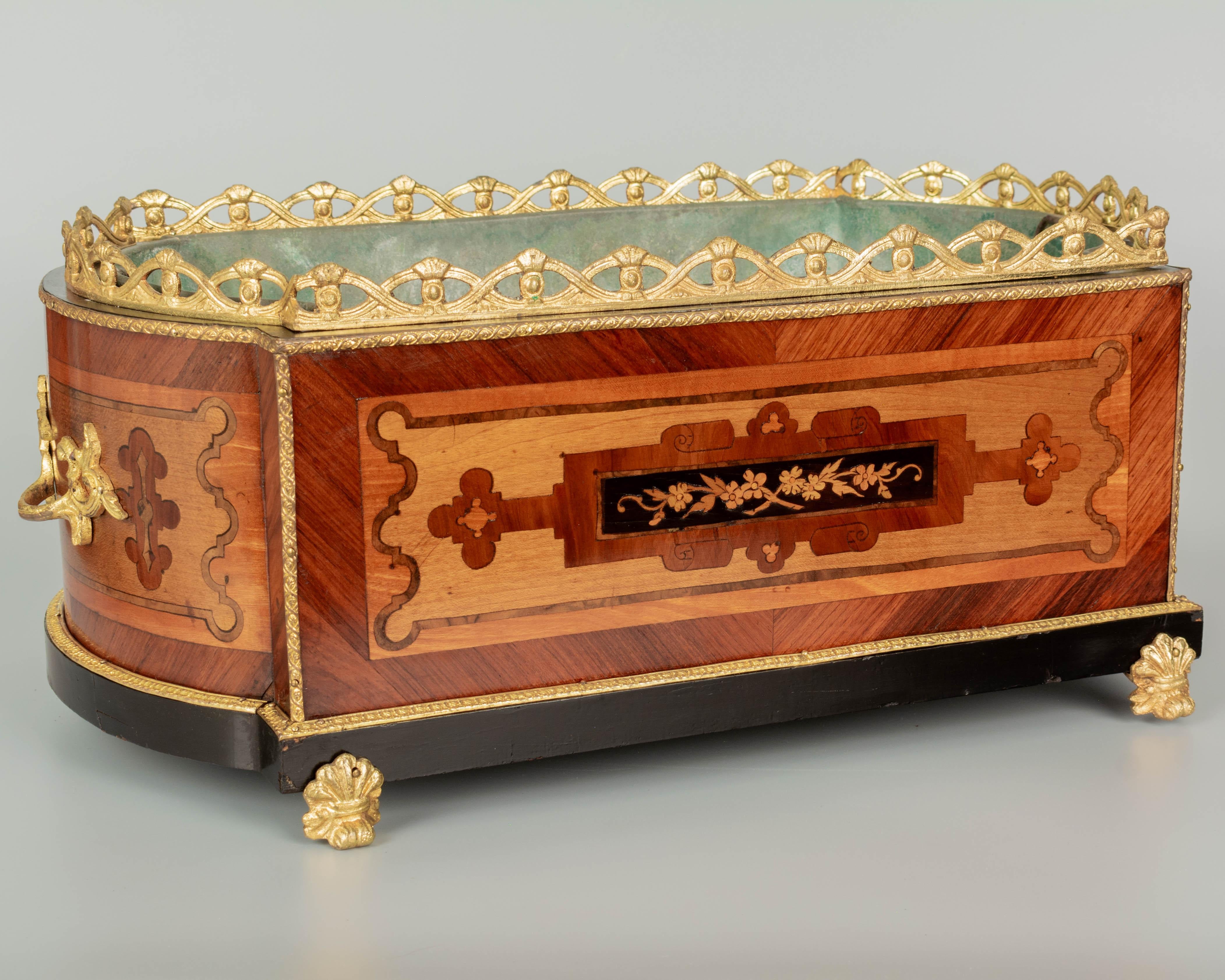 An early 20th century French Napoleon III marquetry jardinière with inlaid veneer of mahogany, maple and yew wood with ebonized trim. Bronze-mounted with two handles, gallery and trim. Original green painted zinc liner. A beautiful planter for the