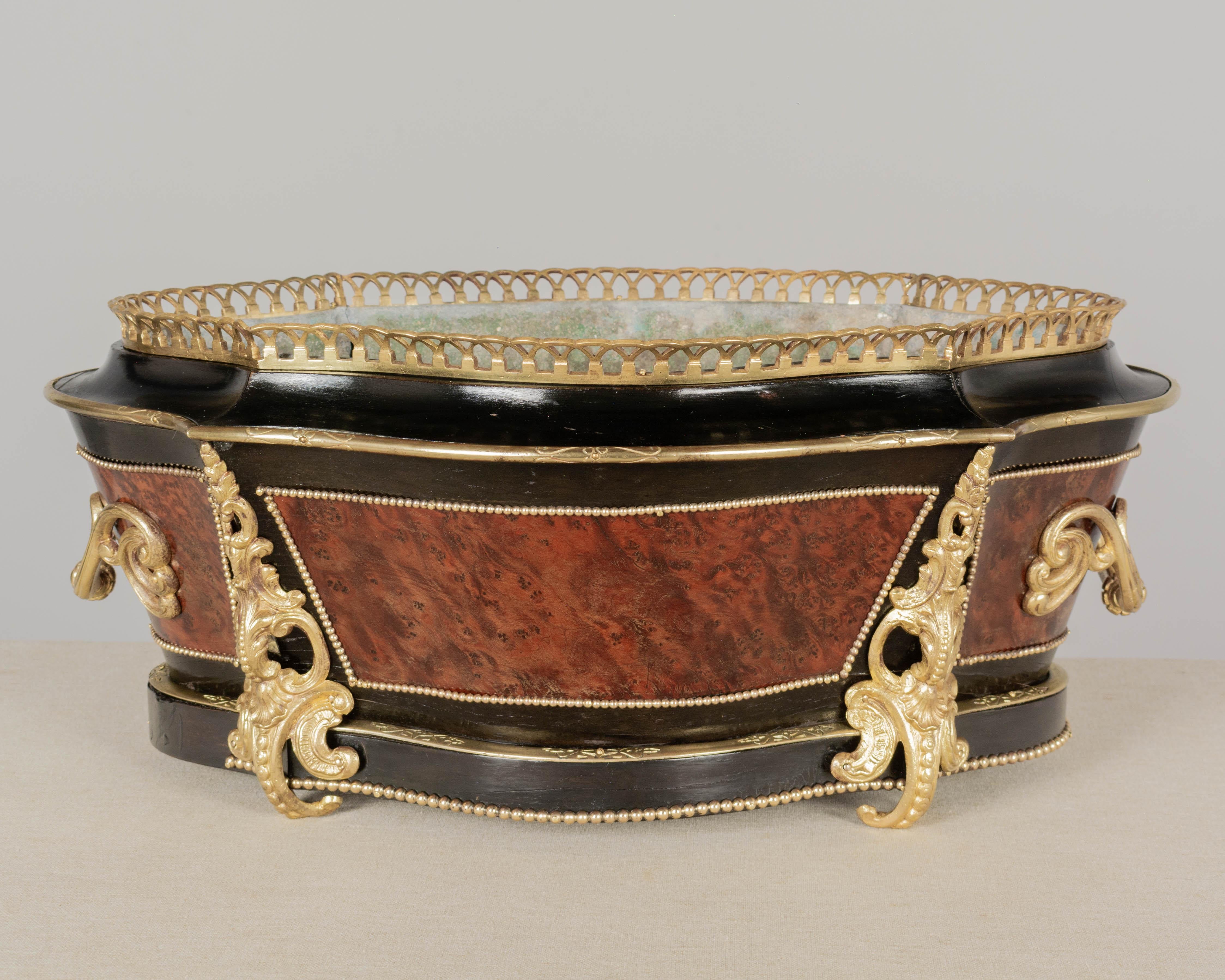 A 19th century French Napoleon III marquetry jardinière with unusual form, ebonized finish with burl of walnut veneer detailed with bead trim. Fine quality cast bronze handles, gallery and large corner ornaments (weighing a total of 6 lbs). French