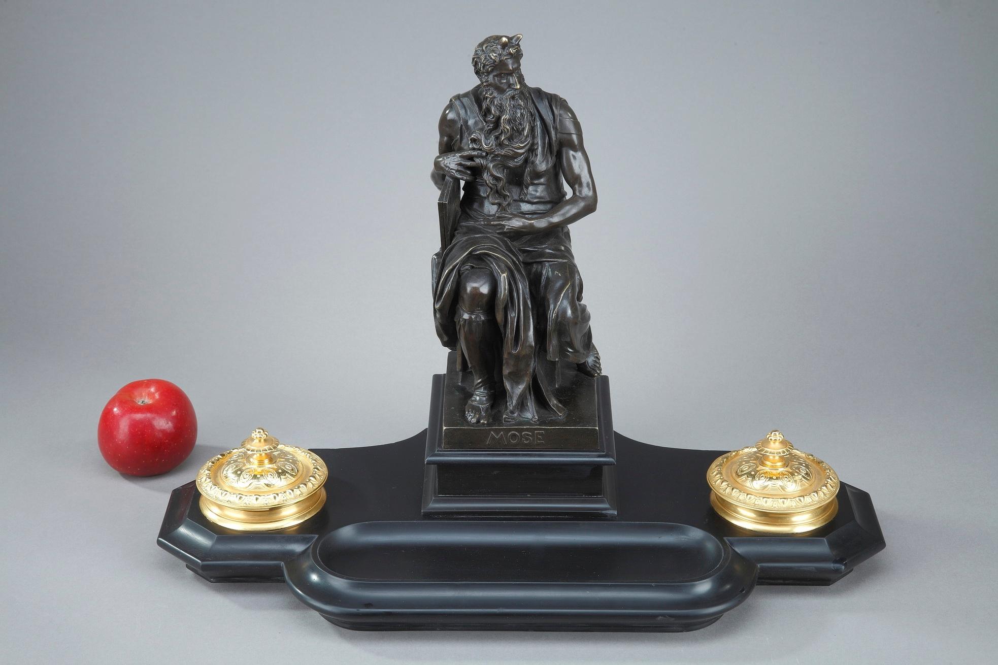 19th century black marble inkwell surmounted by a patinated bronze statue featuring Moses by Michelangelo. The statue of Moses, commissioned in 1505 by Pope Julius II for his tomb and housed in the church of San Pietro in Rome, is a masterpiece of