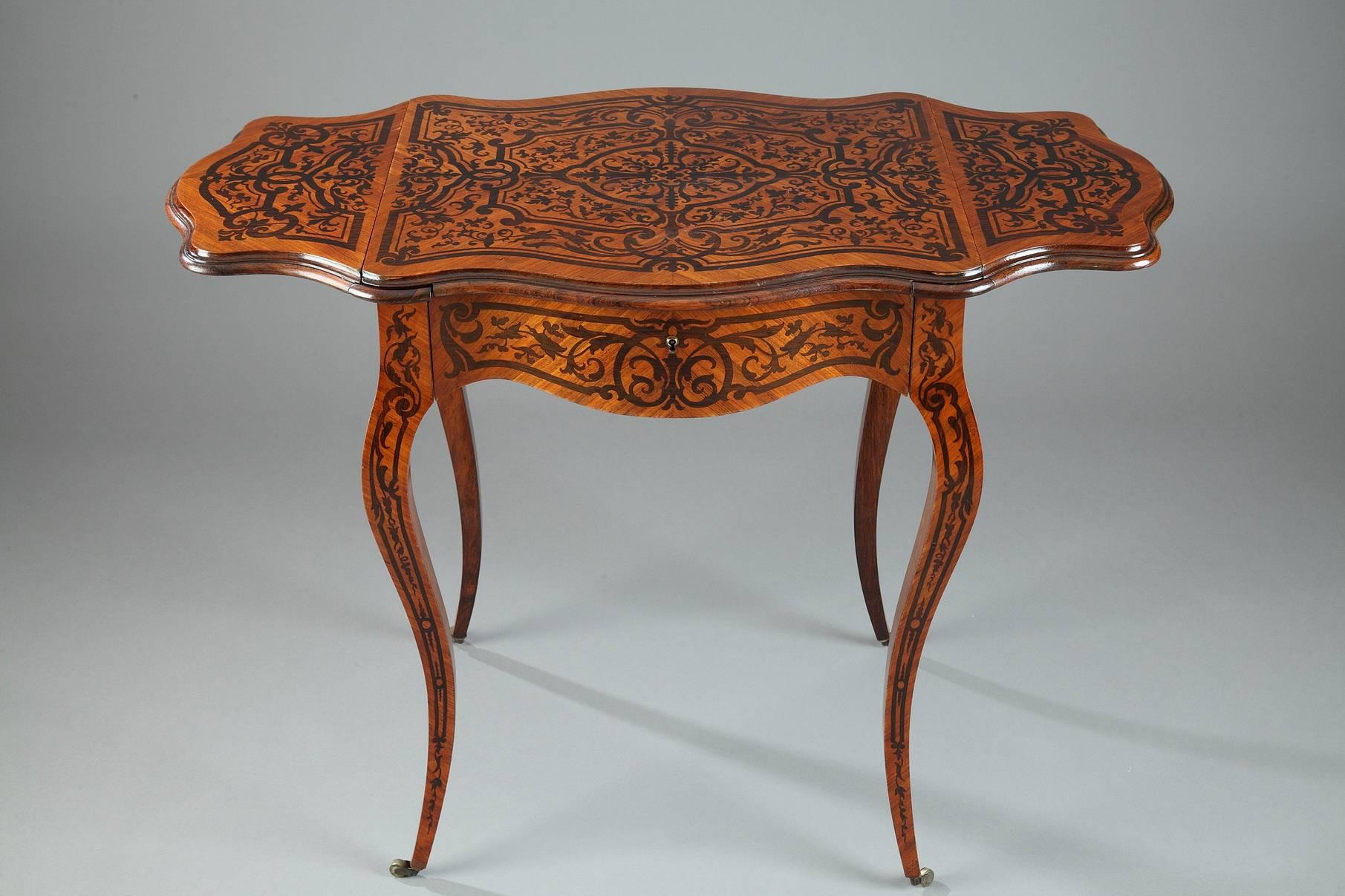 Napoleon III sewing table in rosewood marquetry with flowery branches, rinceau and scrolls decoration. The tabletop has two shutters that open on both sides of the central platter, over a veneer maple storage compartment. It rests on four curved