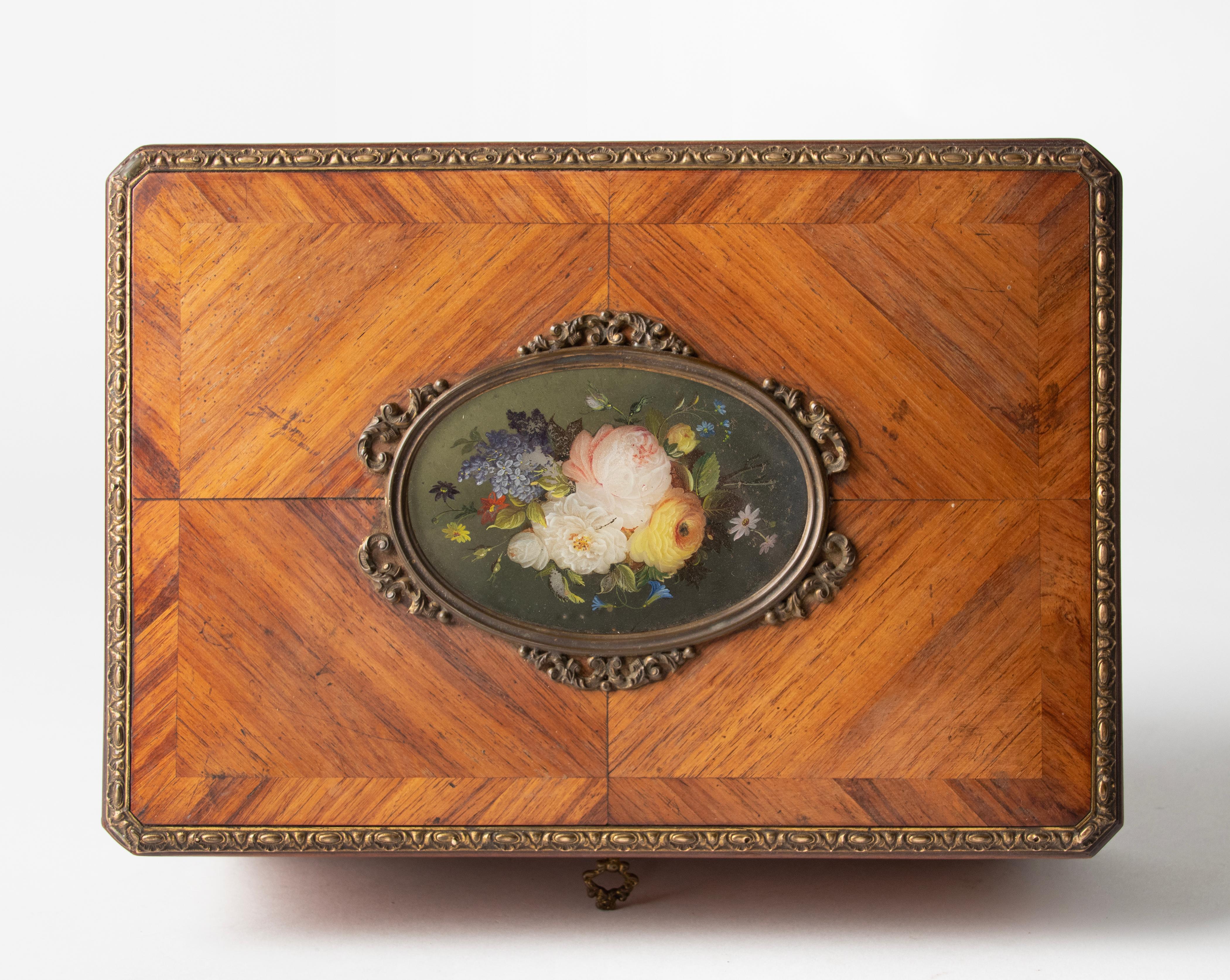 Beautiful antique storage box from the French Napoleon III period. Marquetry inlay with bronze mounts and on the lid an oval painting of a flower still life (hand painted).
The interior is lined with light colored silk fabric. To box is in good