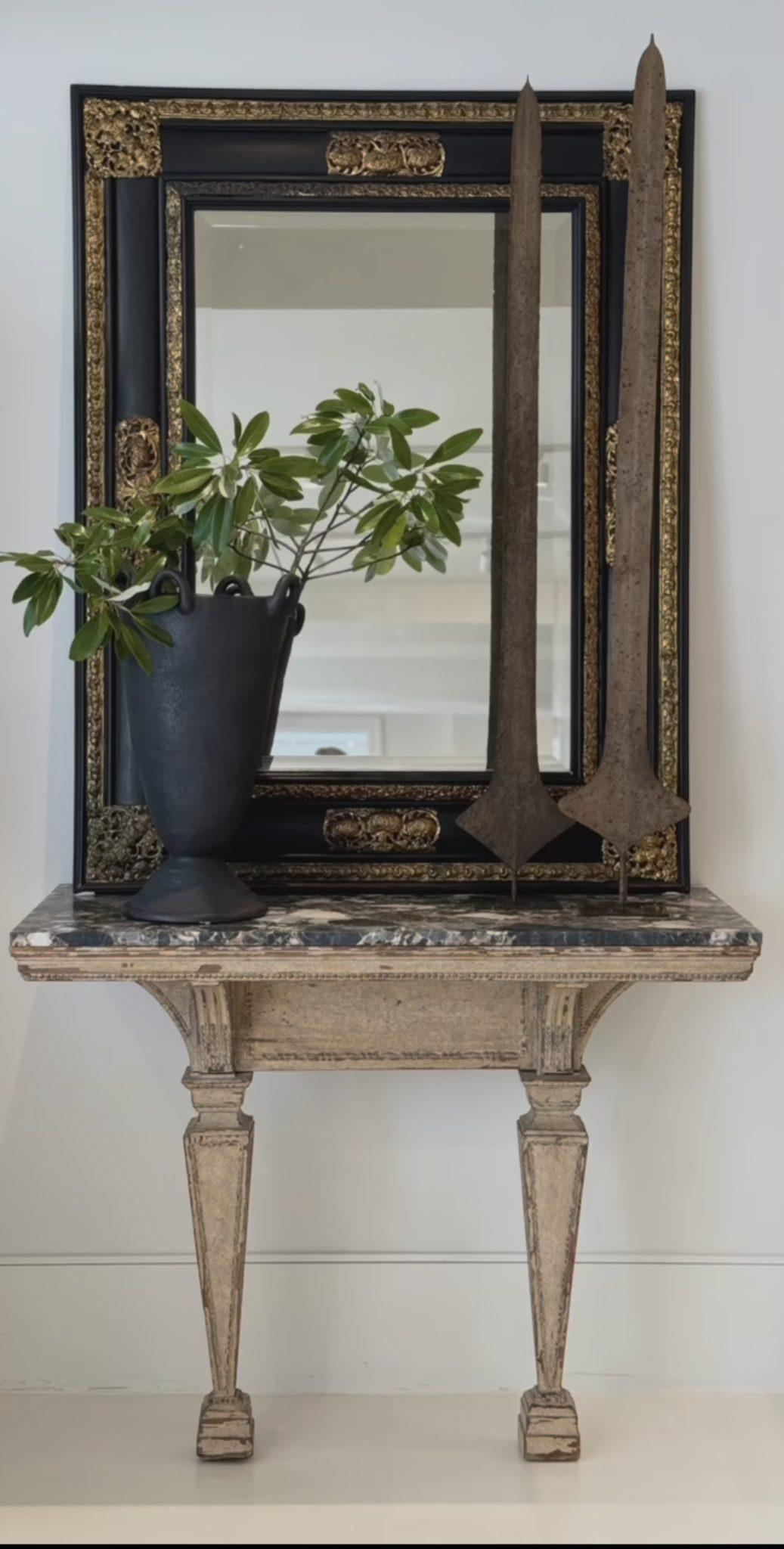 Magnifique, grand et follement élégant miroir en noir avec d'extravagantes applications de repousse dorée.  Ce miroir biseauté est une pièce remarquable. 