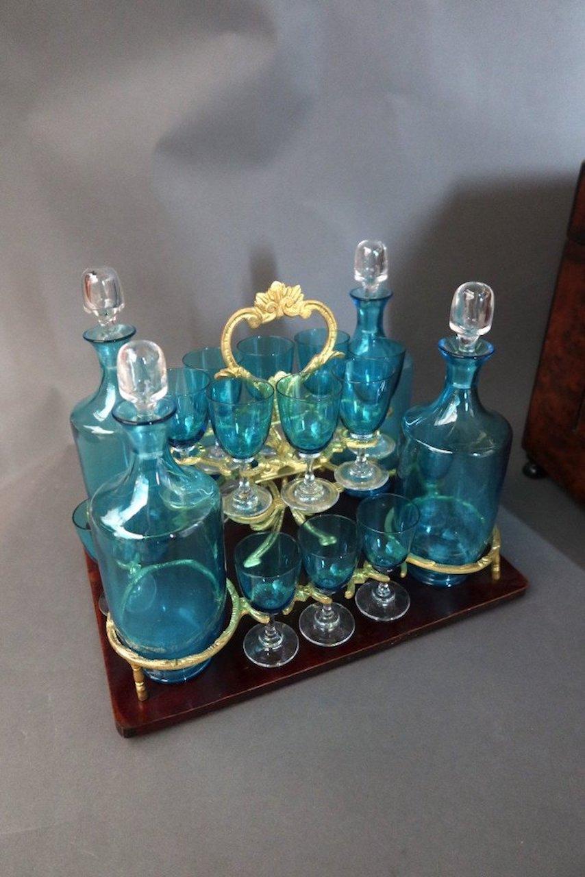 Liquor cellar in magnifying glass and marquetry of brass and mother-of-pearl. 
The facade is curved, the removable tray contains 15 glasses (1 missing) and four
blue glass carafes. Napoleon III period.