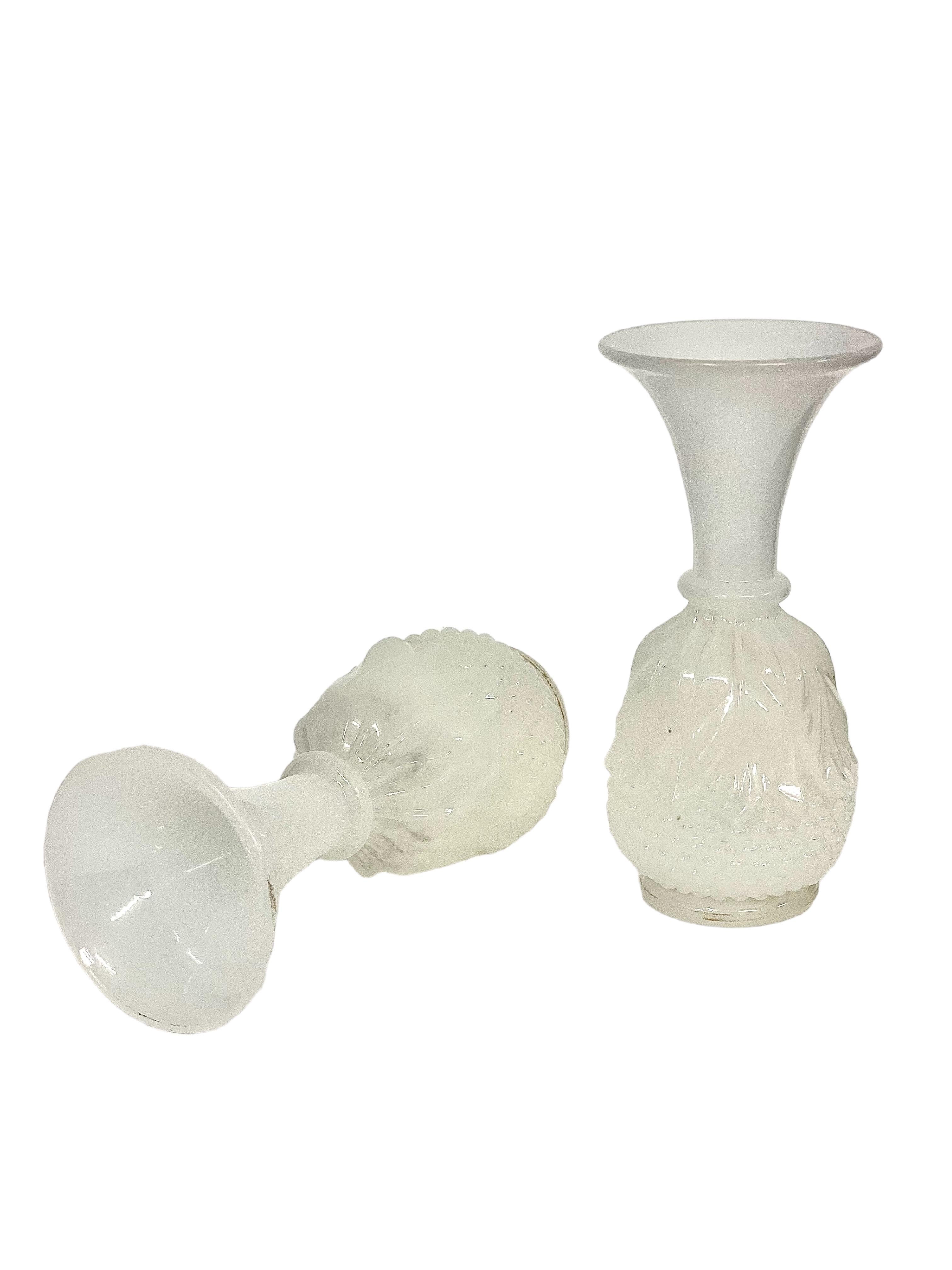 A very attractive pair of matching white 'soapy' opaline antique French vases, dating from the Napoleon III period (mid-19th century) and each beautifully modelled with a pronounced 'trumpet' shaped neck. The body of each vase is decorated with a