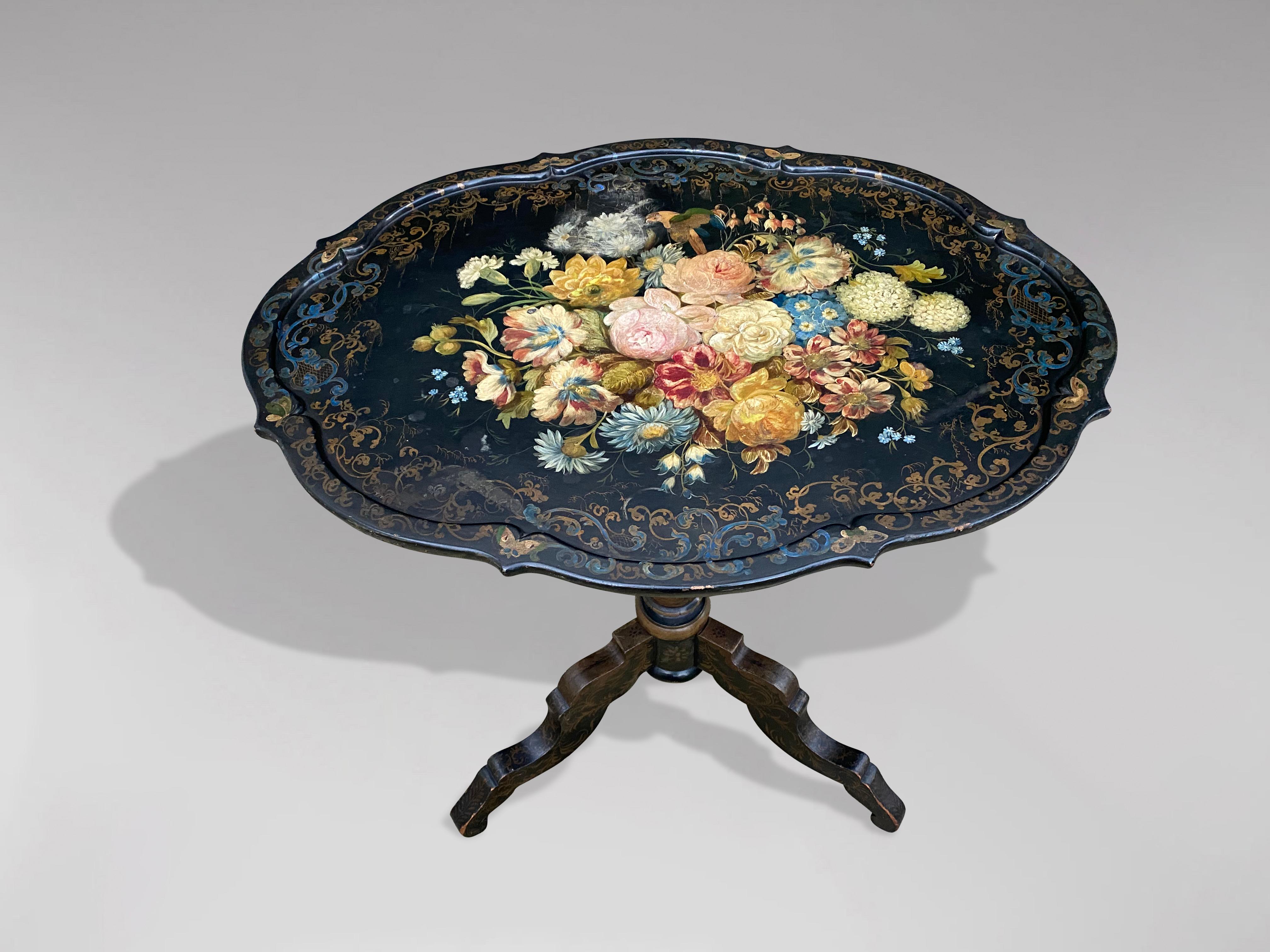 A stunning 19th century French Napoleon III ebonised and floral painted tilt-top gueridon table. With beautiful painted floral and gilt decoration to the shaped top and painted gilt decoration to the tripod base. Featuring its original brass lock