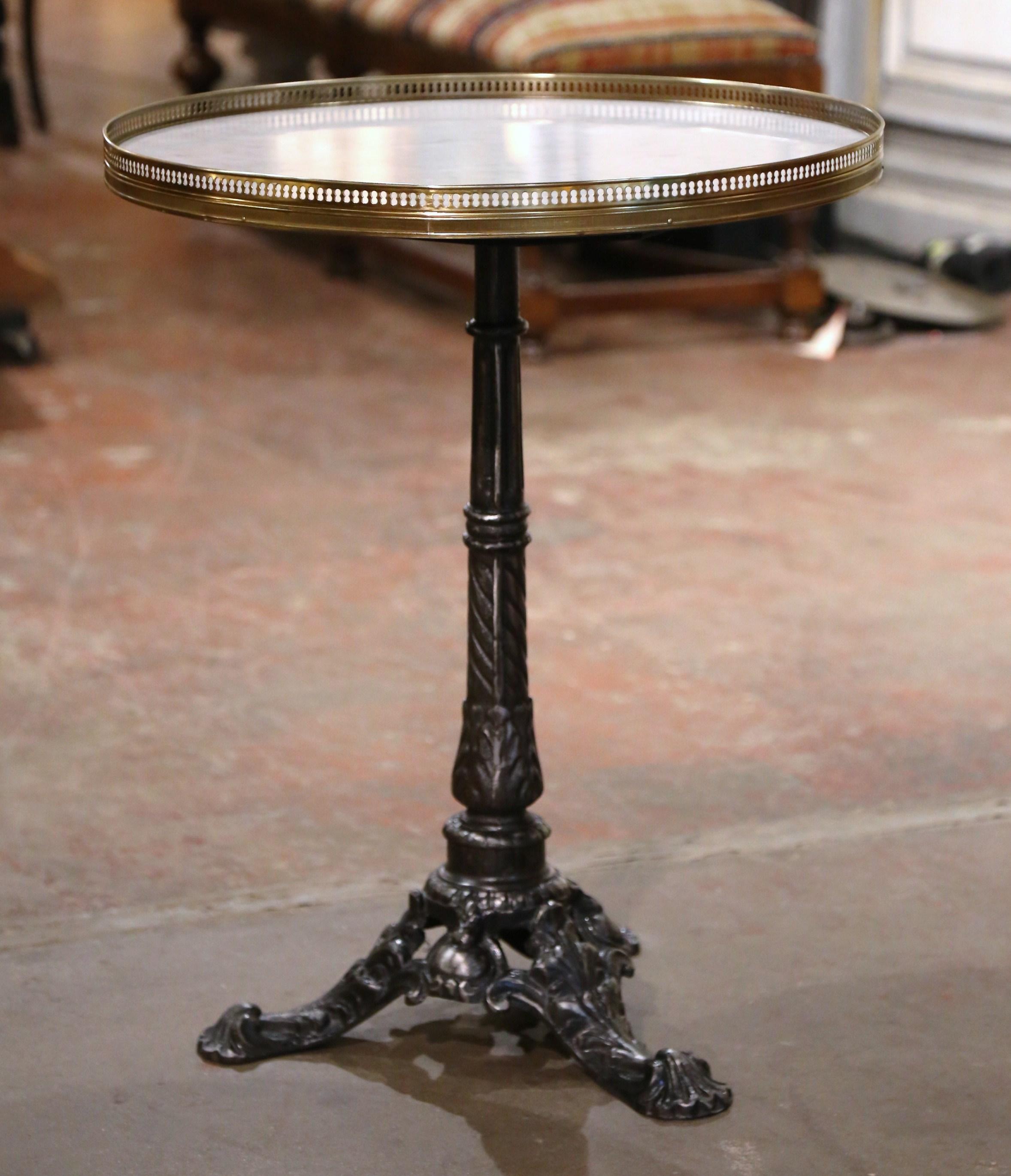 This beautiful antique gueridon was crafted in Paris, France, circa 1870. The intricate iron base sits on three paw feet over a carved stem embellished with acanthus leaf motifs. The surface is dressed with a white and grey marble top set inside a