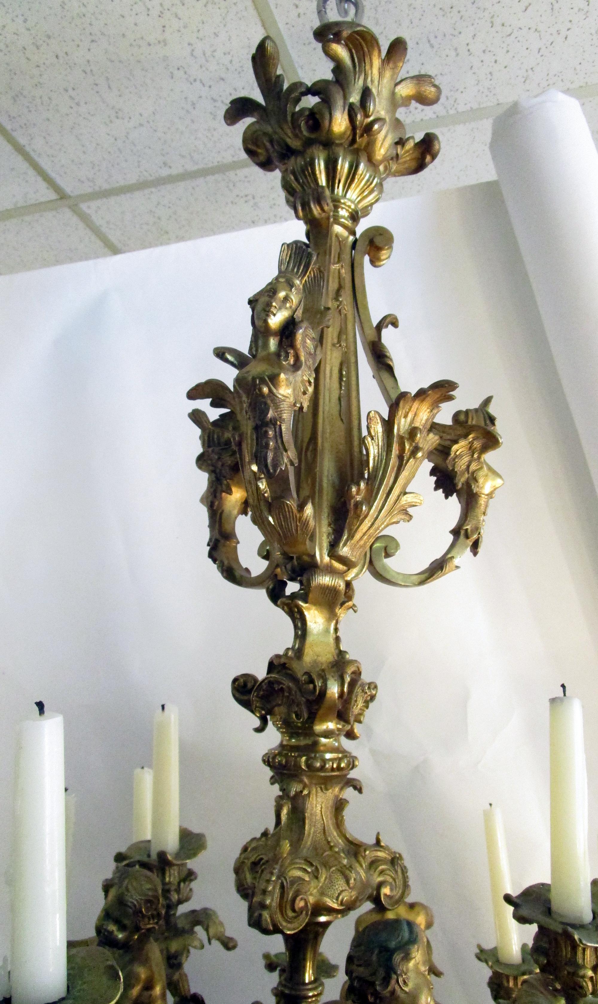 19th century French gilt bronze Napoleon III chandelier signed Raulin. Exquisitely modeled in a variety of figure head busts and leaf forms, it features three putti supporting the branches holding a total of fourteen candles. The Raulin firm was