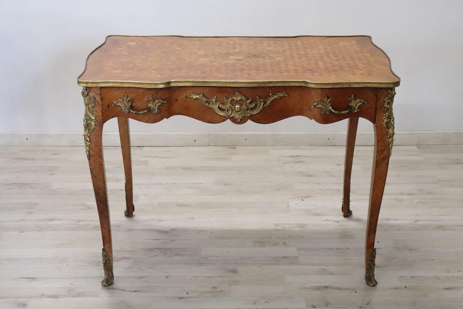 Spectacular 1880s French antique desk in precious rosewood and walnut marquetry. The line is typical of the Napoleon III with elegant wavy legs. Rich decoration in finely chiseled gilded bronze makes this desk even brighter. The front with one