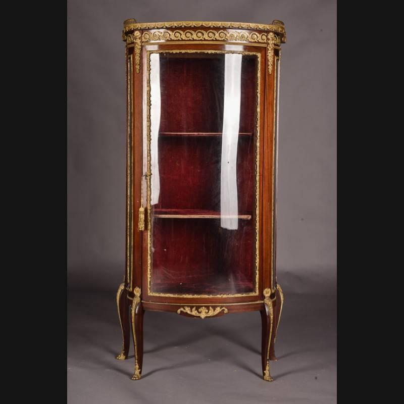 Delicate French vitrine in transition or Napoleon III style, circa 1870.
 solid wood. High-rise, one-door, cambered and three-sided glazed body. On curly feet scalloped out.
Three-sided glazed Vitrine. Slightly protruding top plate with brass