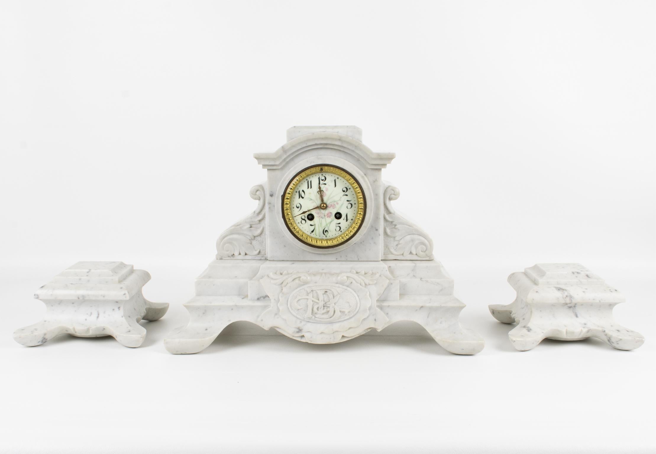 This exquisite 19th-century Napoleon III white Carrara marble mantel clock set by J. Bondat France is a stunning and rare timepiece of French craftsmanship. The set is hand-carved with a neo-classic geometric design and intricate acanthus leaves