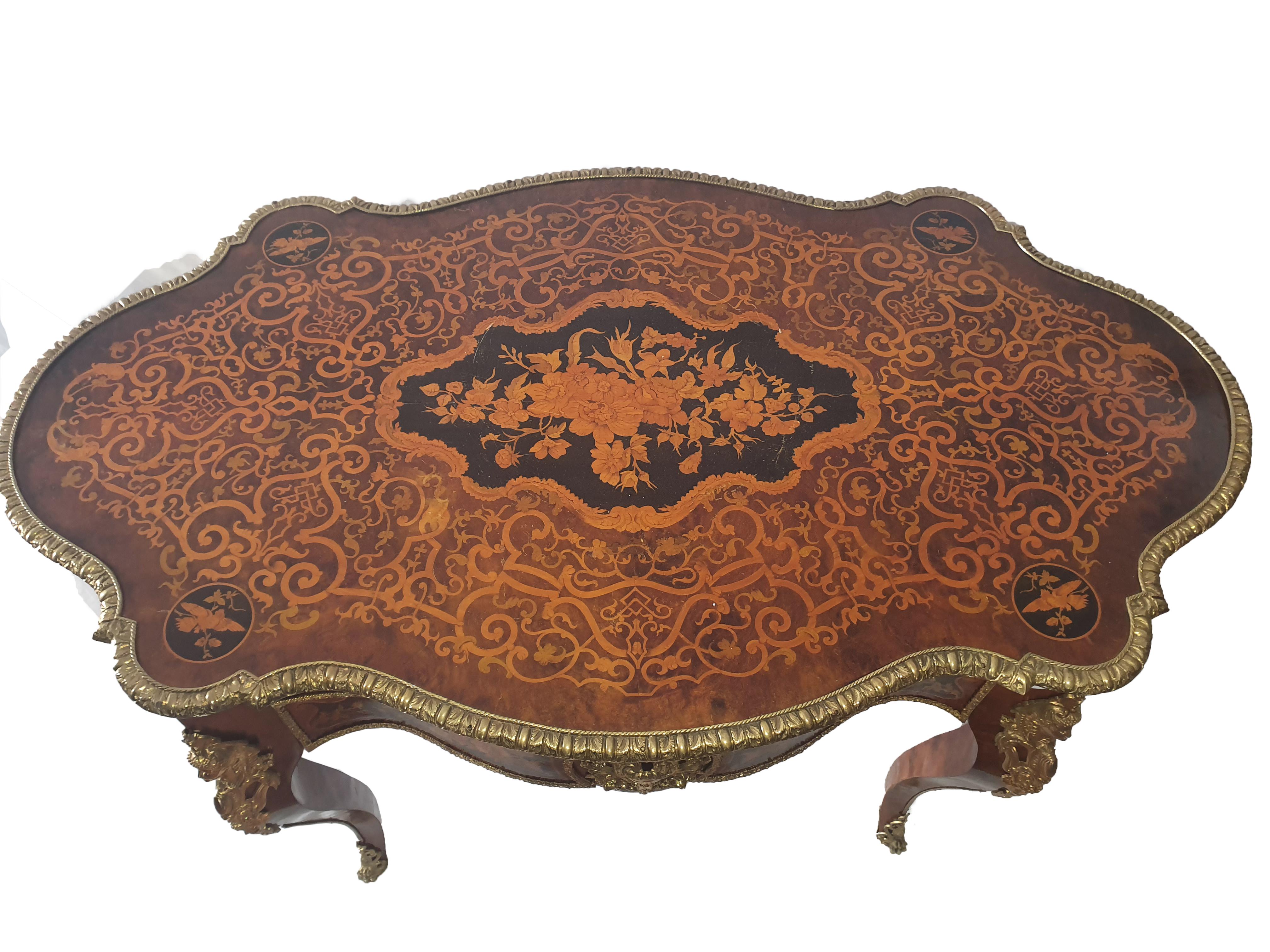 Elegant bureau en bois de noyer, finement incrusté d'un motif floral avec bois fruitier. Des applications importantes en bronze doré ornent le bureau.