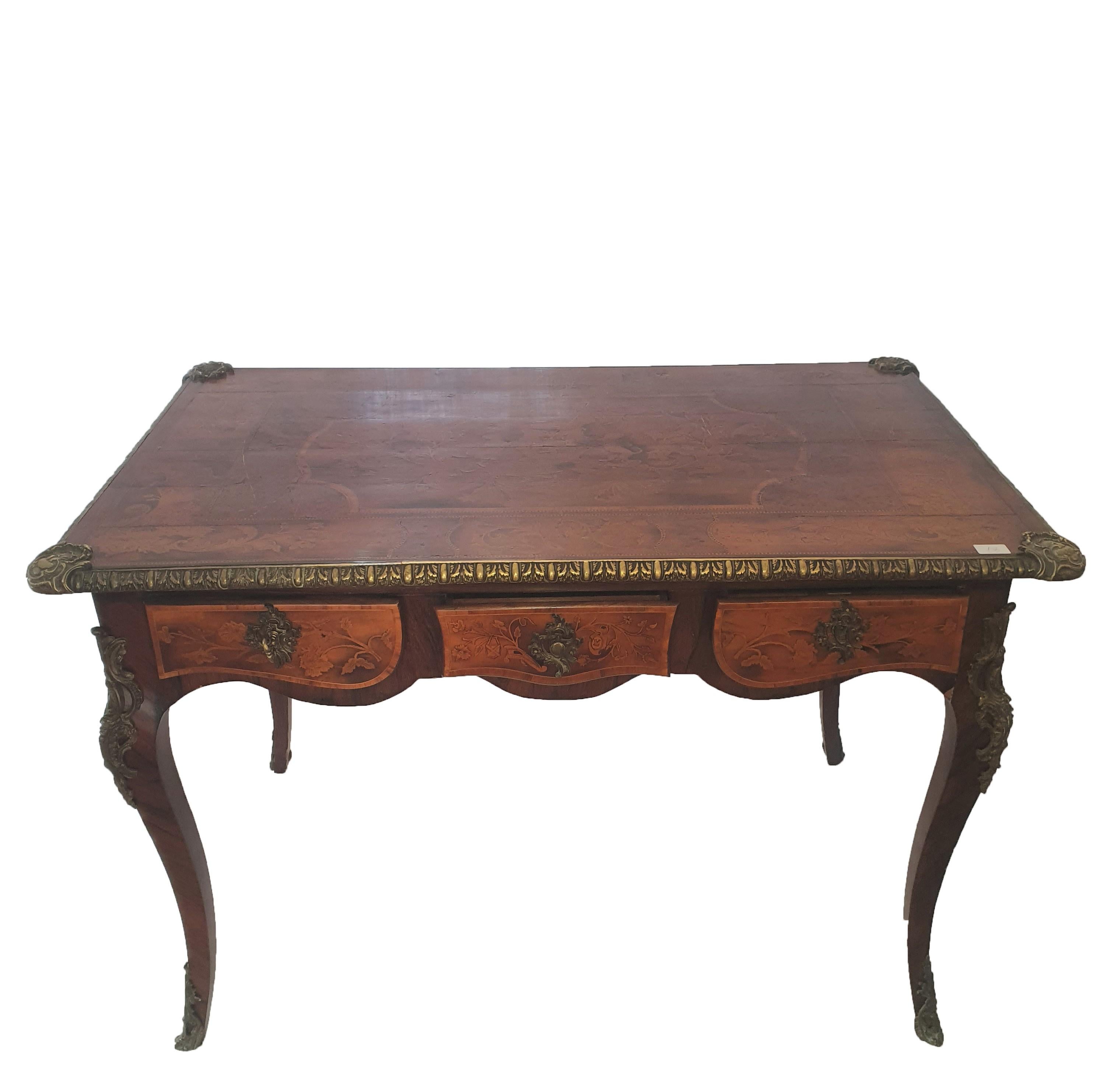 Elegant walnut desk, finely inlaid with fruit wood. Desk from the center, as it has three drawers on both sides, three fake, three in the front that open. Applications in gilded bronze adorn the desk.