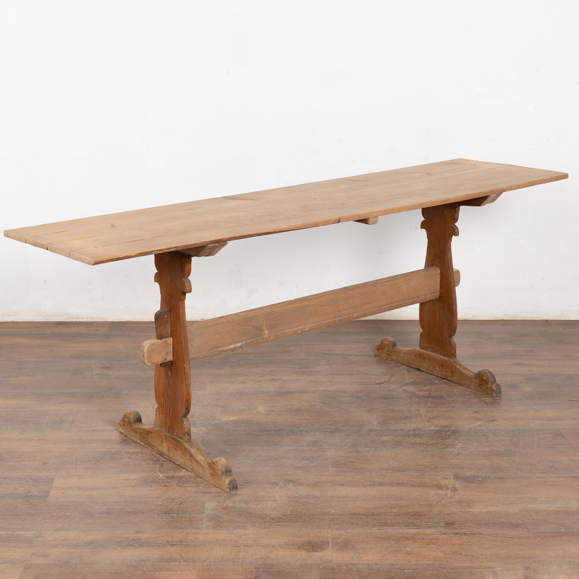 This pine console table likely served as a narrow trestle work table in the Swedish countryside.
The natural pine has been distressed through generations of use, adding depth to the character of the table. The many scratches, cracks (see top) dings,