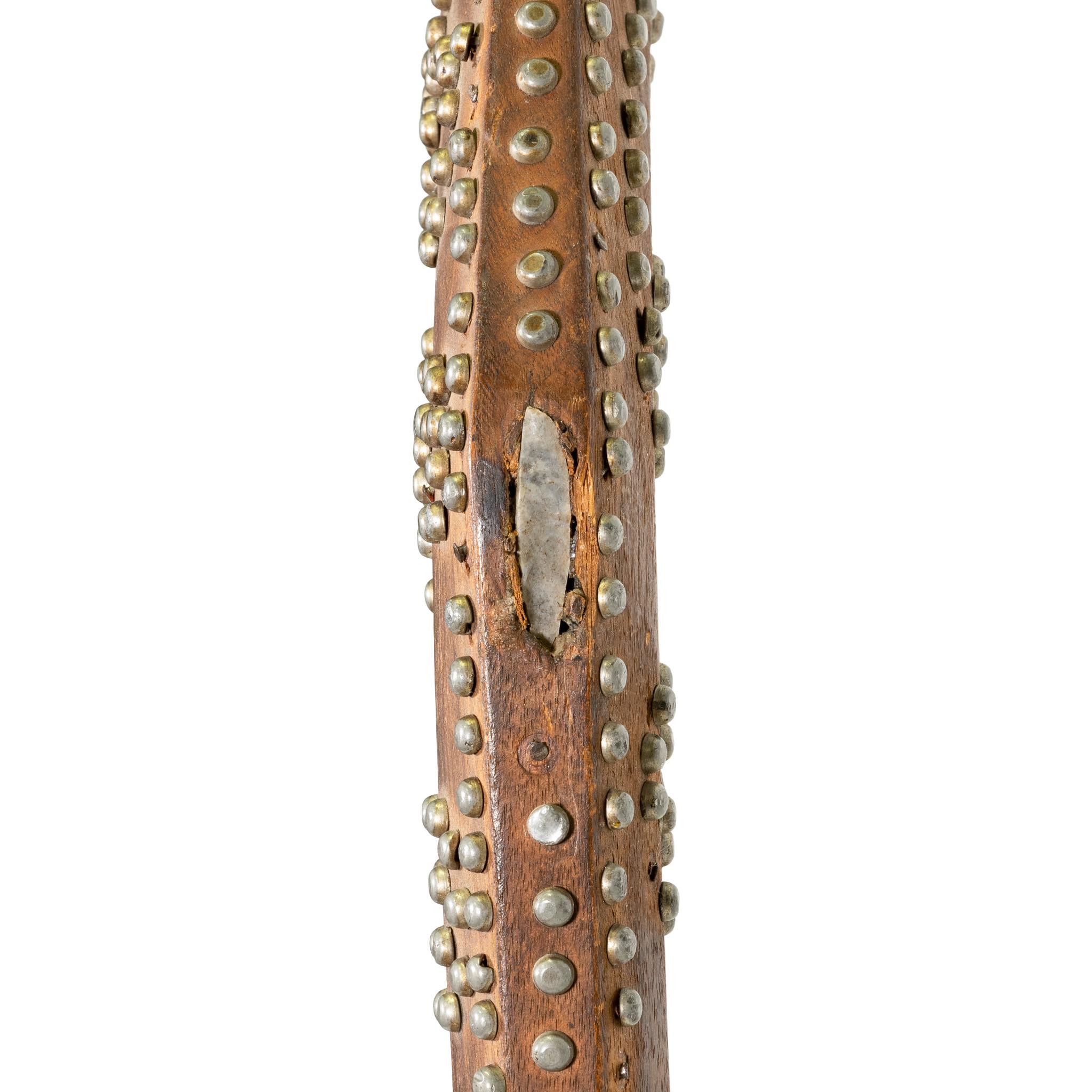 Well tacked Great Lakes gun stock club with tapering hexagonal point. Recessed hand grip and shaft, profusely decorated with a pattern of pewter head iron nails forming zig zag, circular and spirally patterns pierced thru the base and at the head