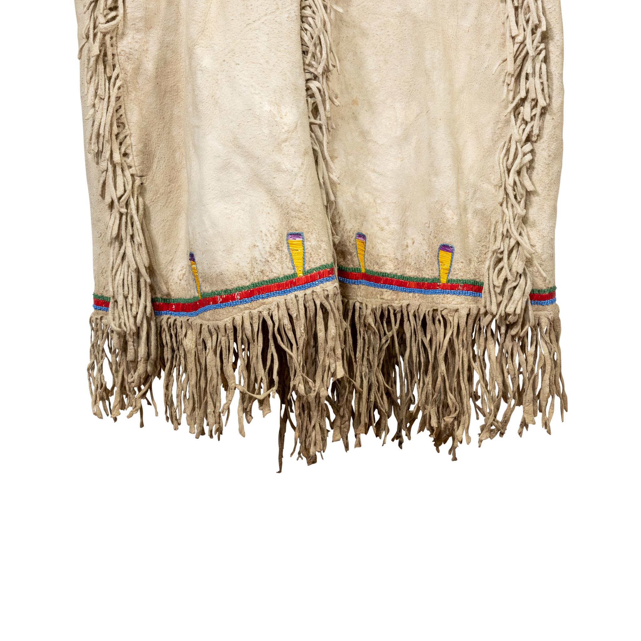 Hidatsa Arikara medicine shirt worn by a warrior who deserved honors, pre-reservation. Horseshoes represent successful horse raids, and the six quilled eagle feathers signify war coups, scalps or battles. Would note, four real scalps possibly moved