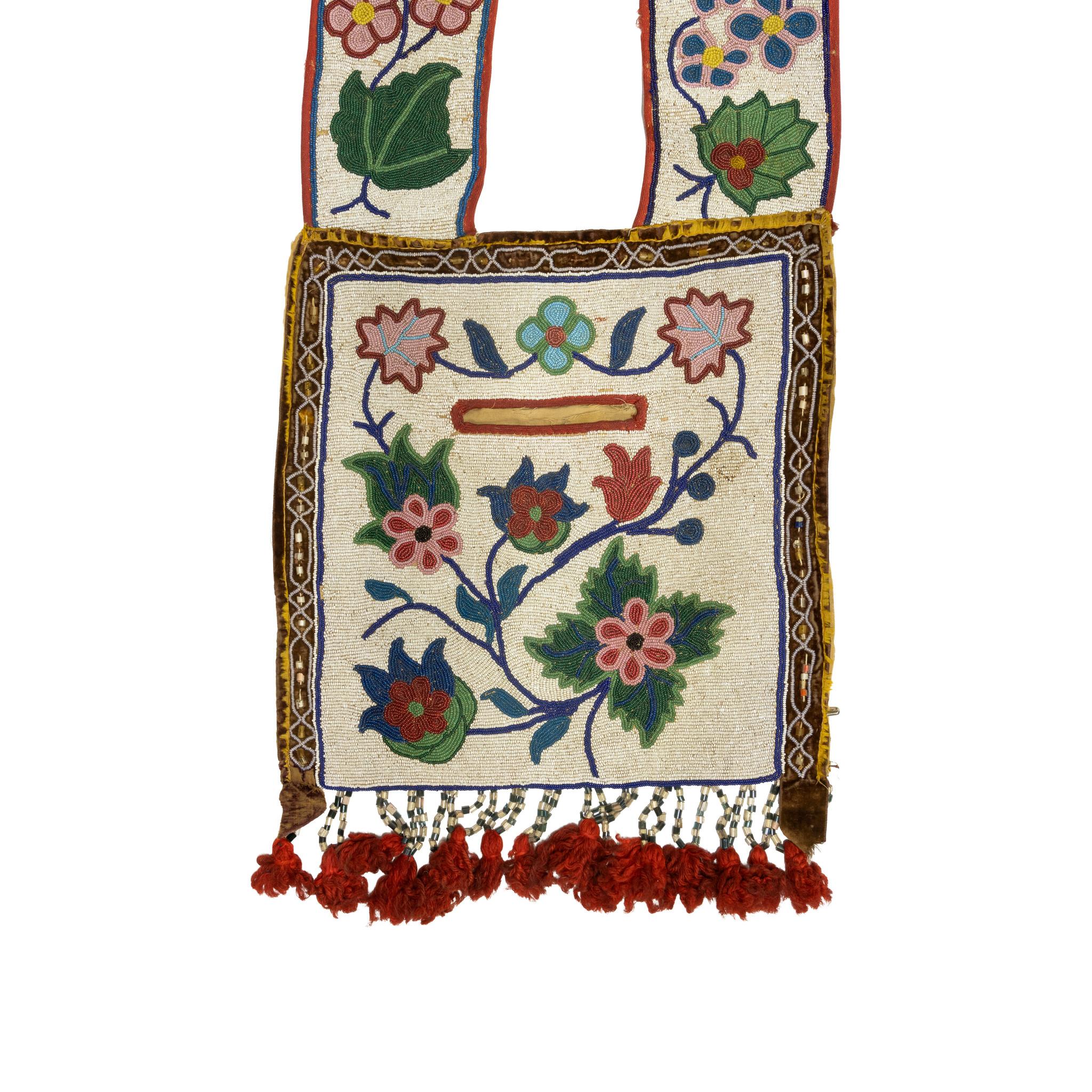 Sac bandoulière Chippewa avec poche. Bordure extérieure unique autour du sac central avec des perles de bugle, et des perles de bugle blanches et rouges se terminant par des touffes blanches au bas. Bretelles assorties avec perles d'ornement et