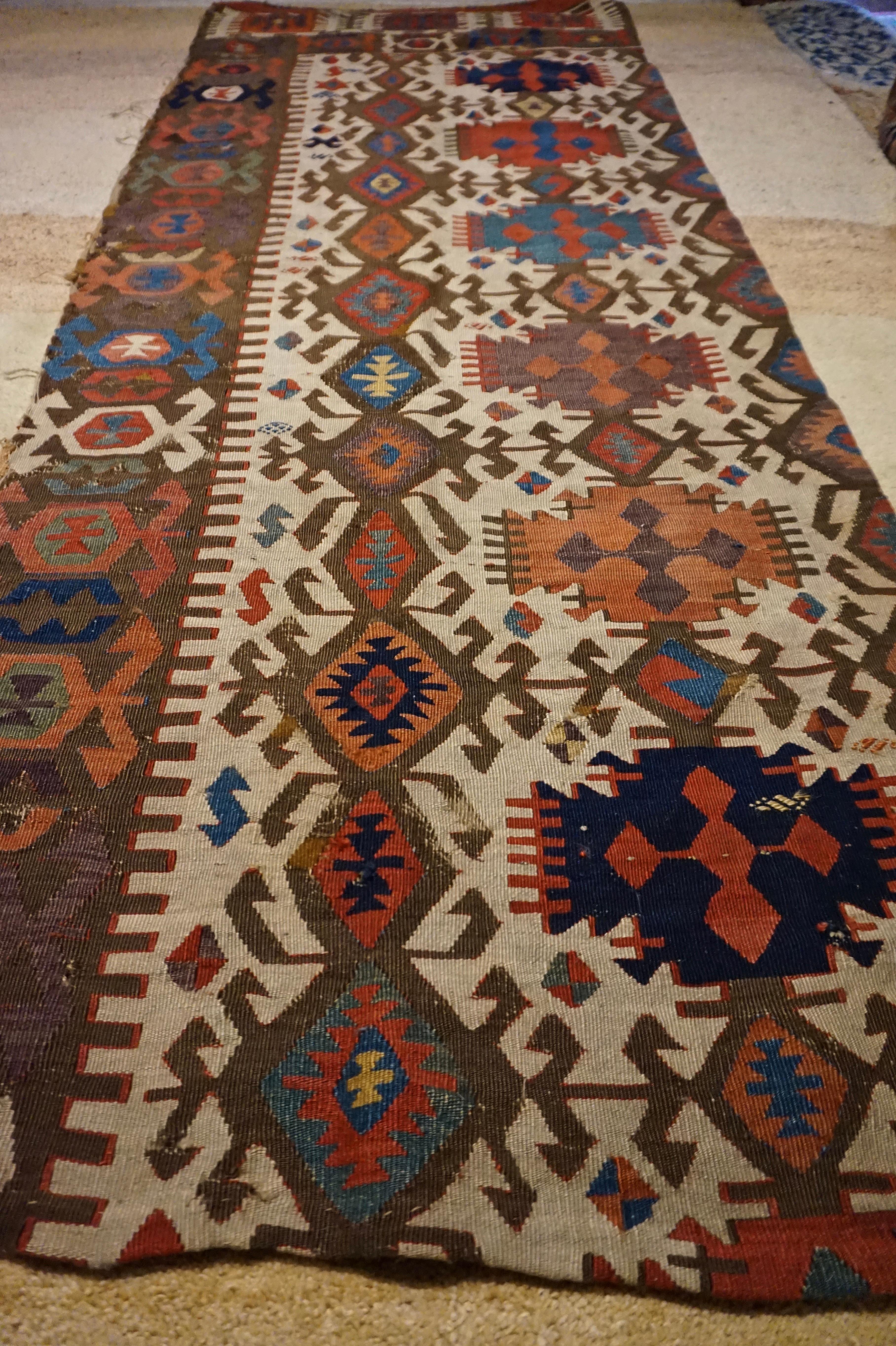 Panneau ancien en Sumak/Kilim du Caucase finement noué à la main avec des teintures naturelles. Des motifs captivants et des teintes chaudes. Quelques traces d'usure sur les bords, mais l'état général est respectable pour l'âge.