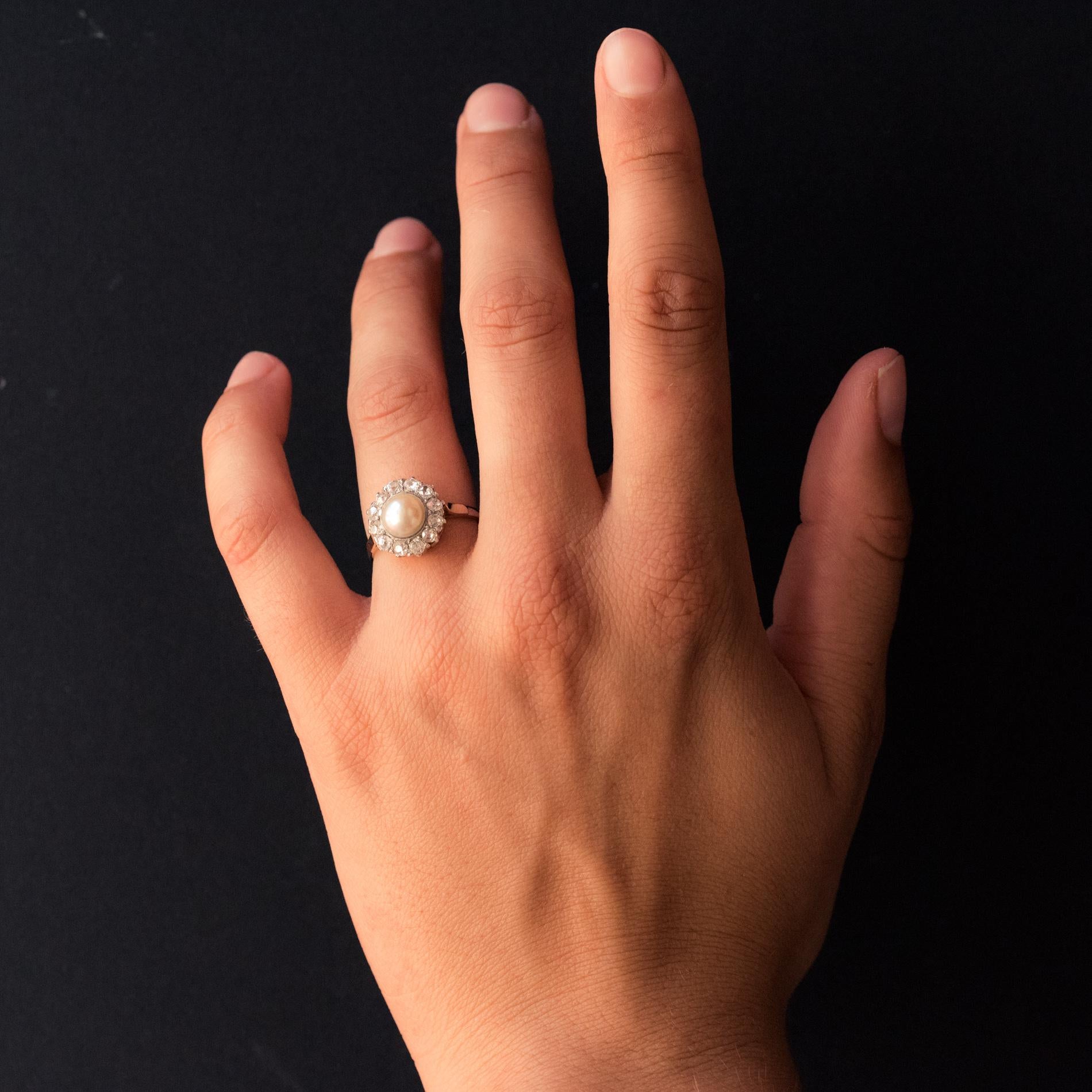 Ring in 18 karat rose gold.
Adorable antique ring, it is set in the center of a natural button pearl, in an entourage of antique cushion- cut diamonds. On either side of the head two gold palmettes form the start of the ring.
Total weight of