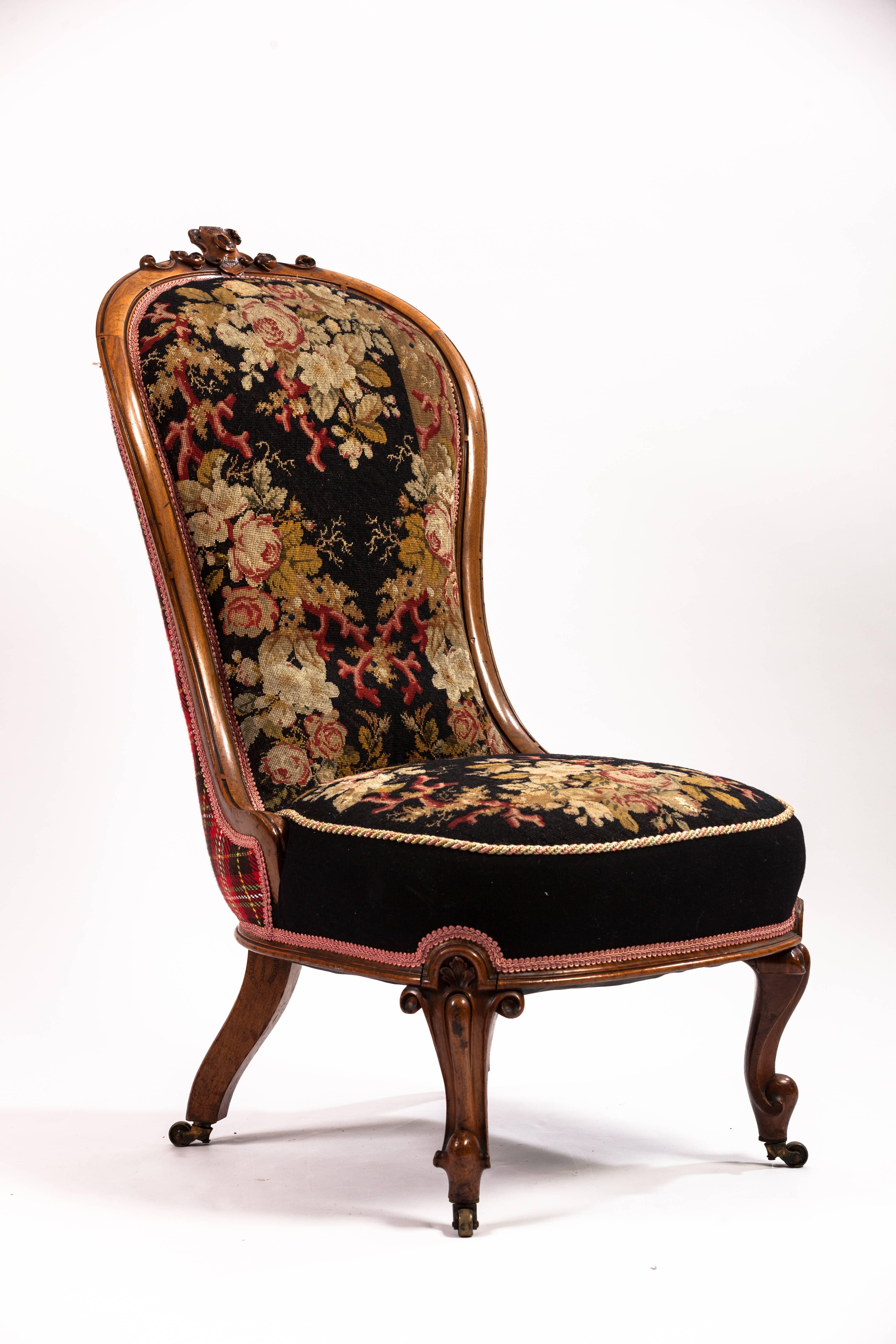English carved walnut slipper chair, upholstered in an antique needlepoint fabric.

Measures: 16