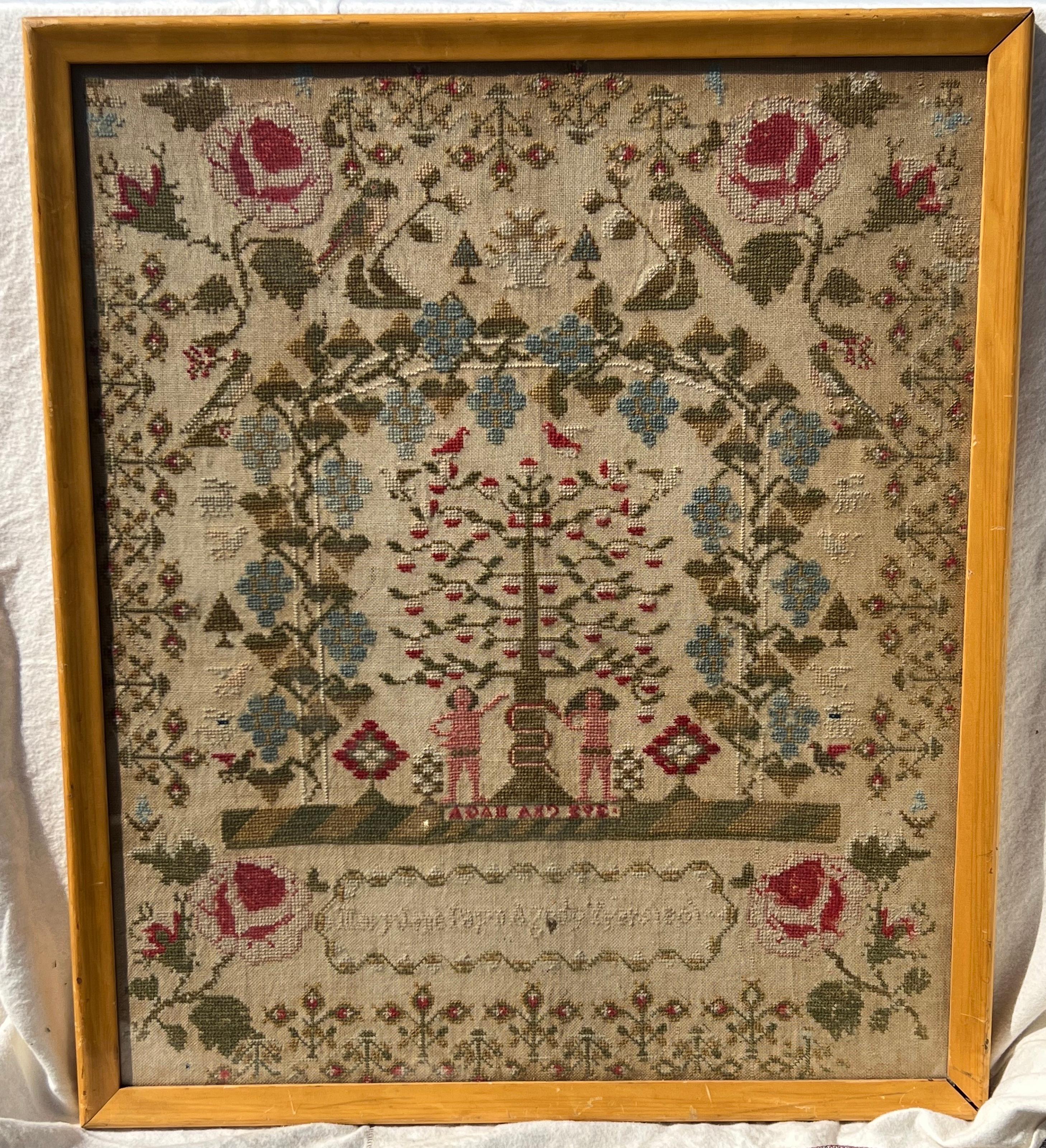 Lovely 19th century needlework sampler with central scene of Adam and Eve, the apple tree, and intertwined snake at the tree's trunk. Surrounded by floral embroidery as well as grapes and grape leaves as well as other flora and fauna. Illegible