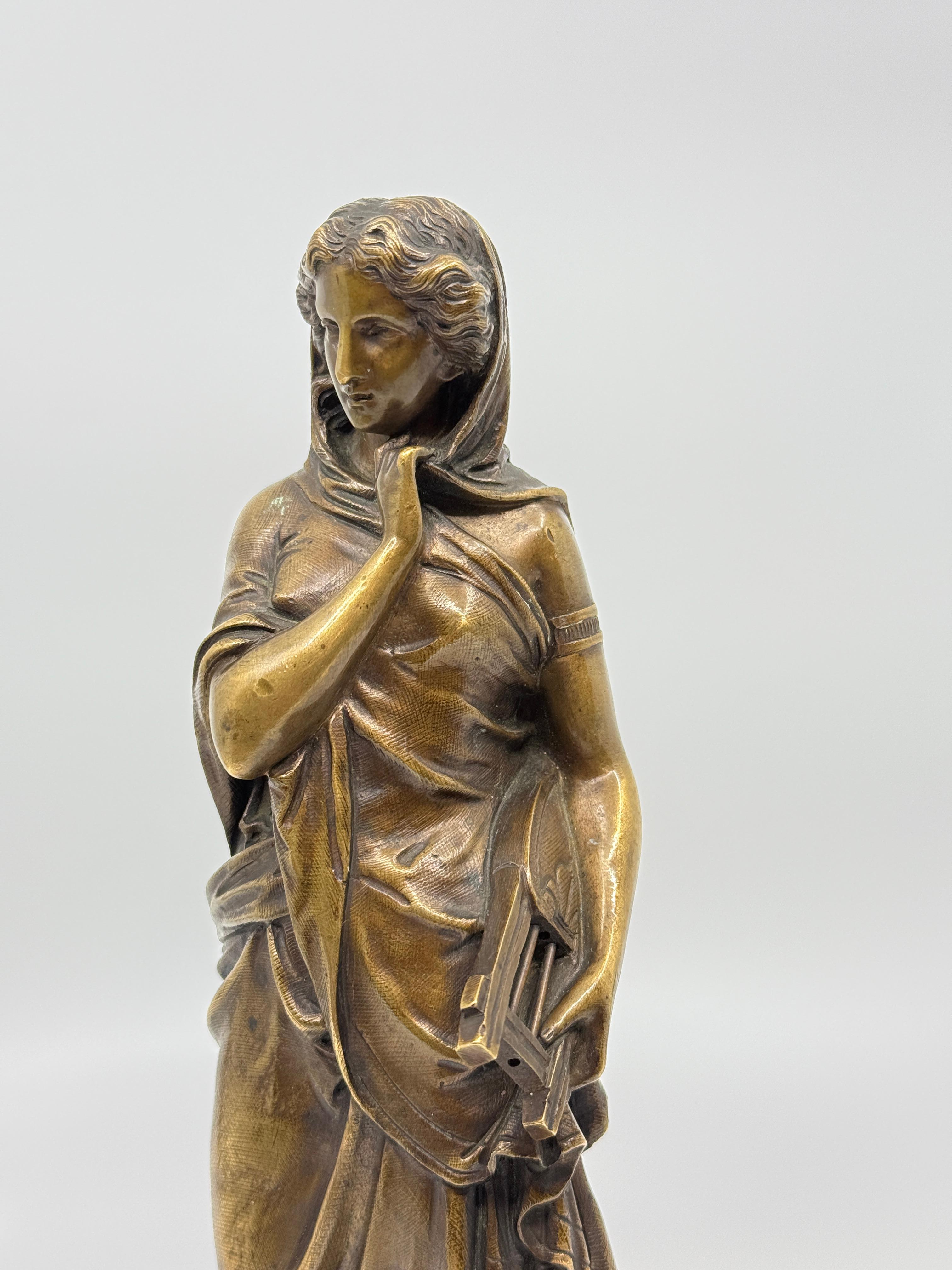 Un bel bronzo neoclassico di una donna drappeggiata in toga con una lira. Montato su una piccola base di marmo. Bella età e patina. 
Firmato, anche se credo che la firma sia stata aggiunta successivamente. 
In buone condizioni d'uso, con usura della
