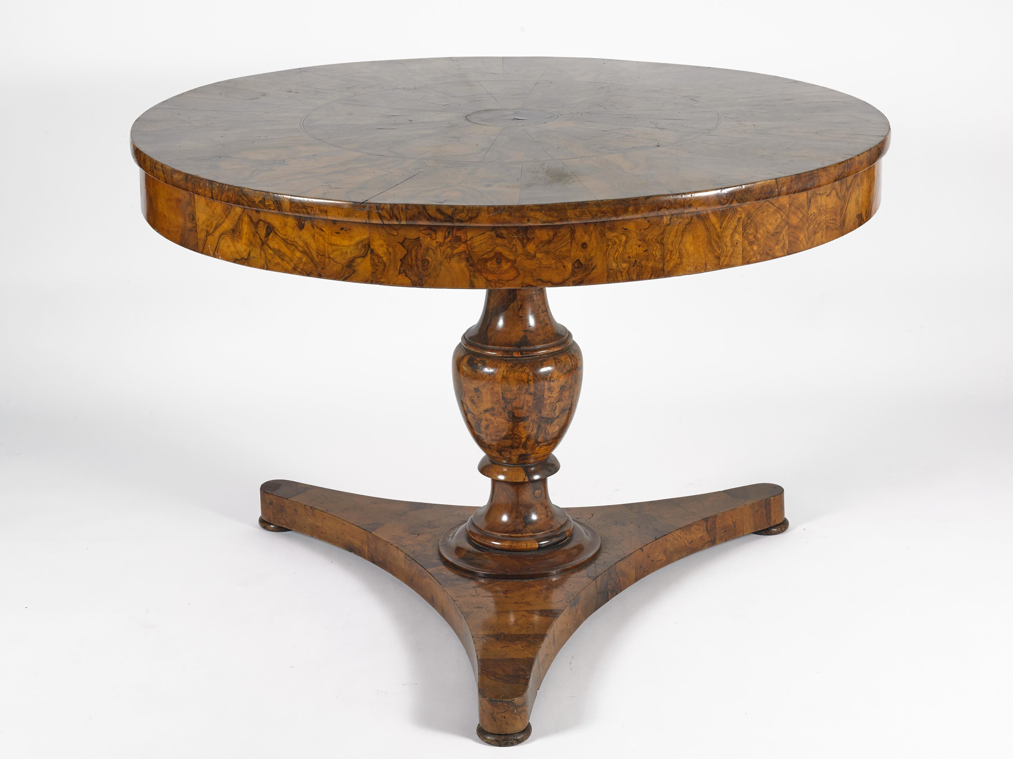 This was acquired in Italy at a private estate sale. The burled walnut wood table sits on a tripod base and makes an elegant center table for an entrance or foyer, or for a cozy corner in a library or study. 

It measures 44.5