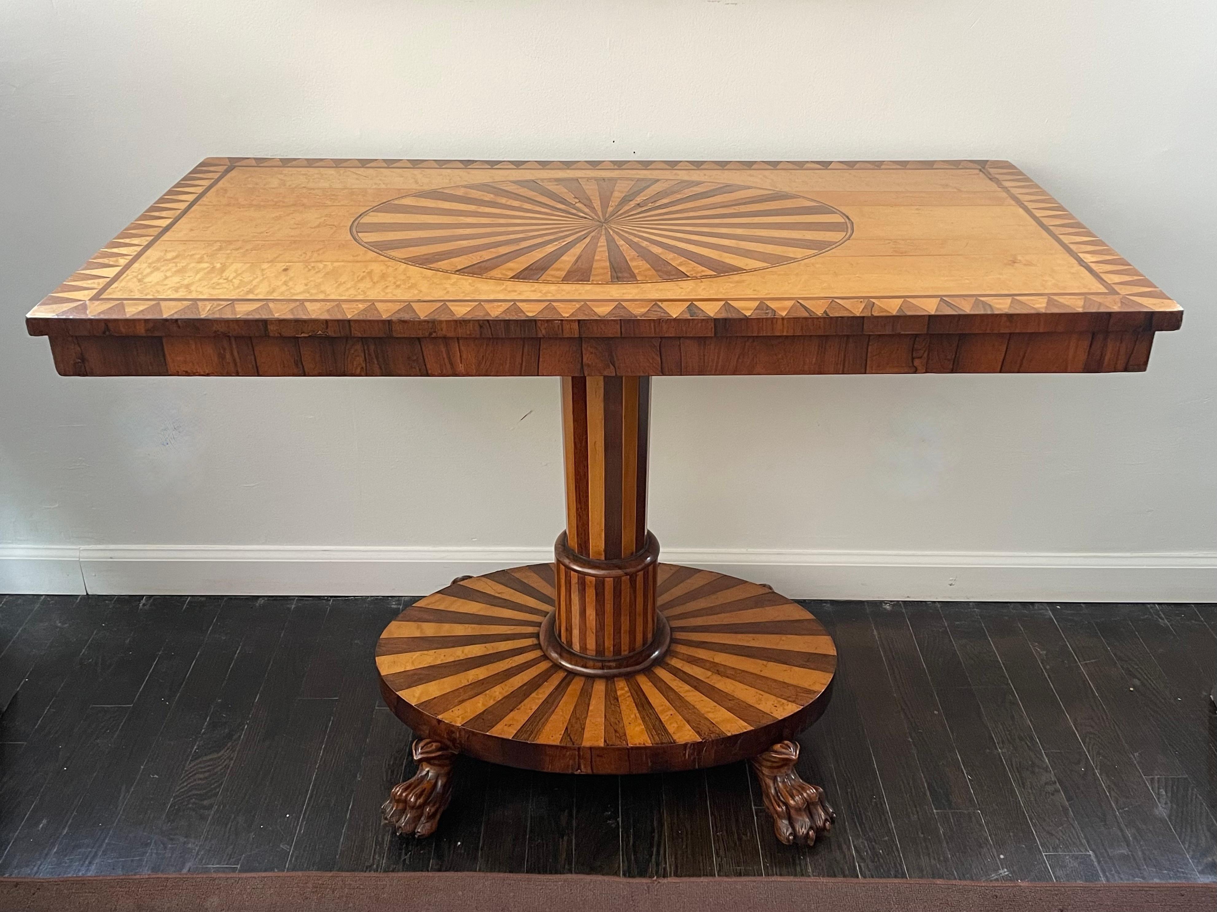 Die kühnen, grafischen und geometrischen Intarsien dieses Tisches aus Satinholz und Palisander erinnern an die Gemälde von Bridget Riley und anderen Op-Art-Künstlern der 1960er Jahre.  Die Musterung erstreckt sich sogar auf die mit Messingrädern