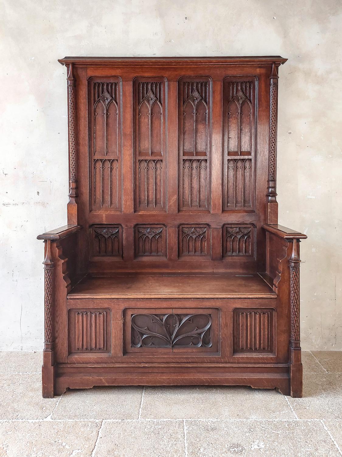 A very attractive 19th century neo-gothic french hall bench made of oak with hand carved decorations. Beautifully carved with gothic details as pointed arches, columns and linnenfold panels. The seat can be lifted as a chest for storage. This very