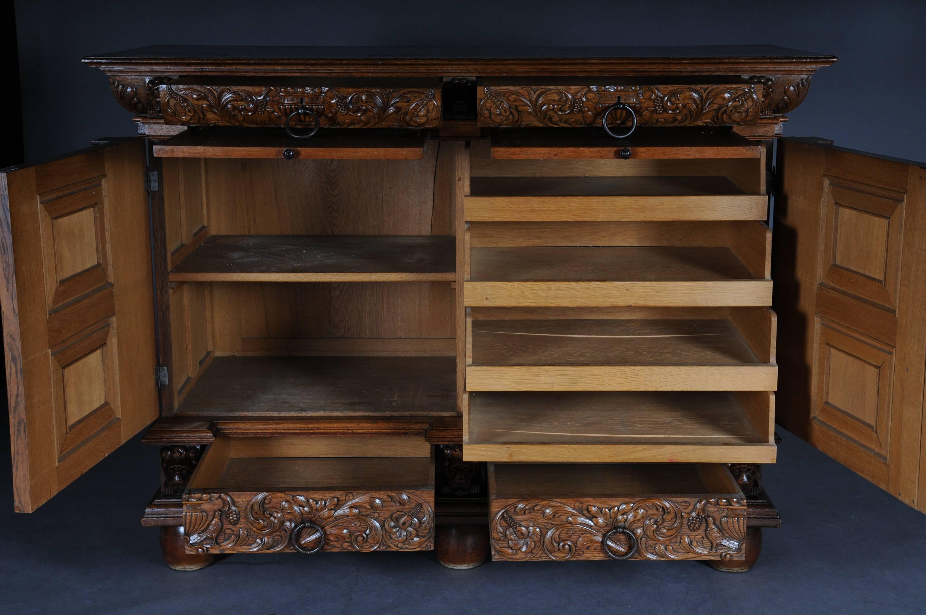 Oak, solid. A two-door casted base with four drawbacks and finely carved mascarons and acanthus leaves, laterally with plastic, meshed, ionic half-columns. Underneath the upper drawers, extendable dressing plates, circa 1890.


(O-232).