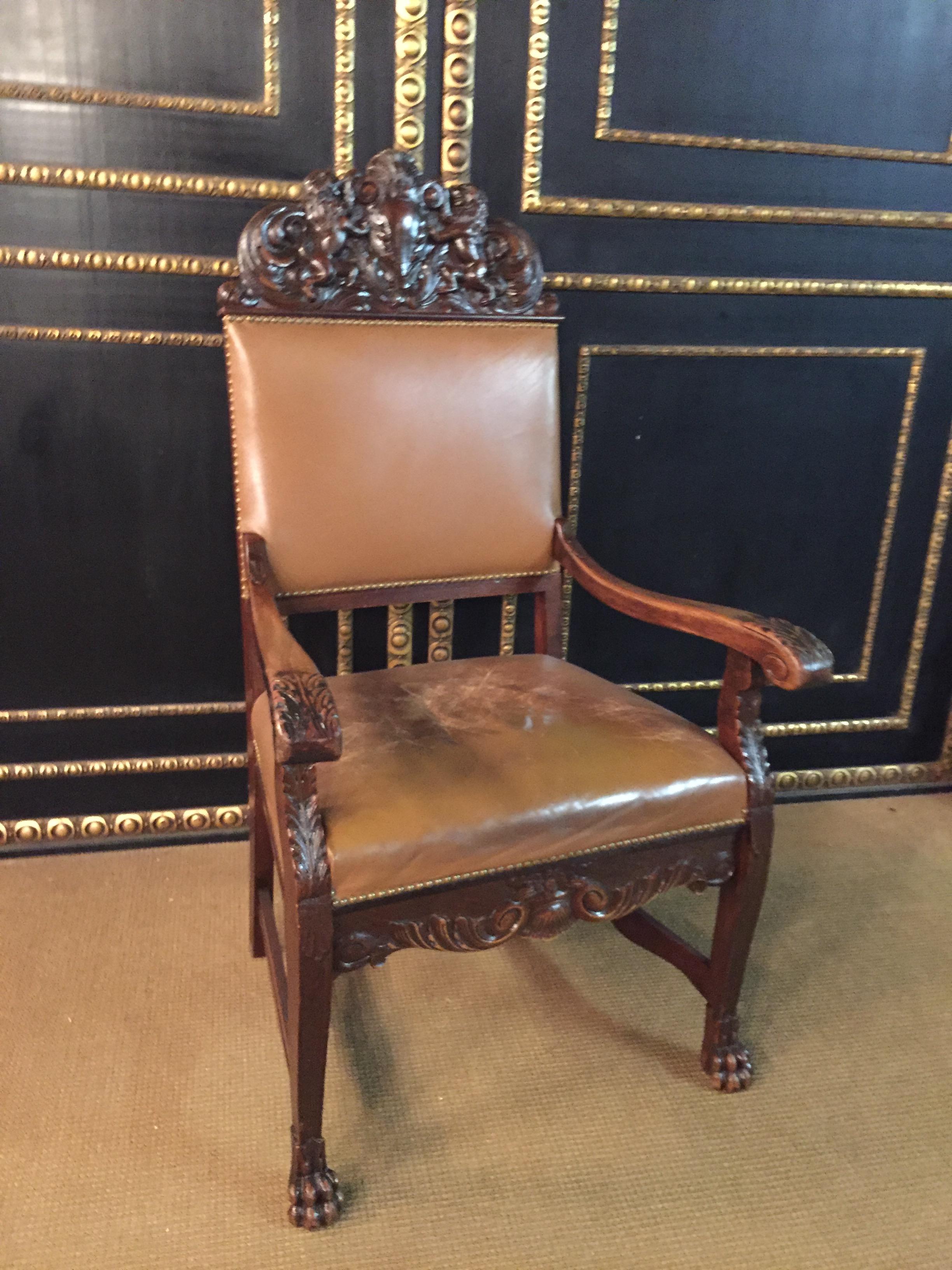 Original neo-Renaissance armchair, circa 1870-1880. Massive dark oak, feet with lion paws connected by wide bridges. Carved on both sides armrests, high backrest with plastic carvings with 2 lions. Seat and back covered with old leather.
