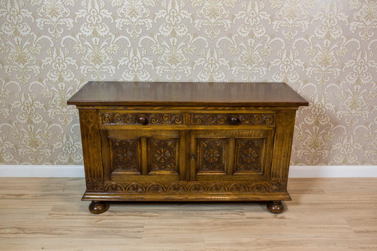 We present you this piece of furniture made of solid oakwood, dated the late 19th century.
The cabinet is two-leaf, with two drawers under the top.
Moreover, the whole is supported on legs in the shape of a flattened sphere, with a slightly